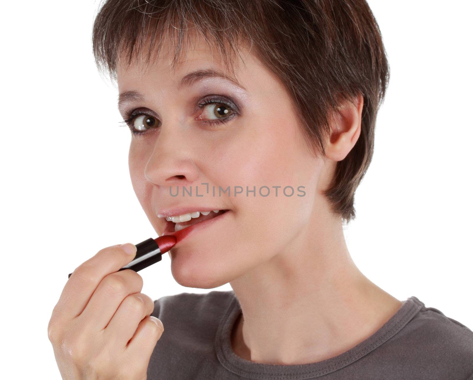 early fourties woman applying mascara lipstick, white background