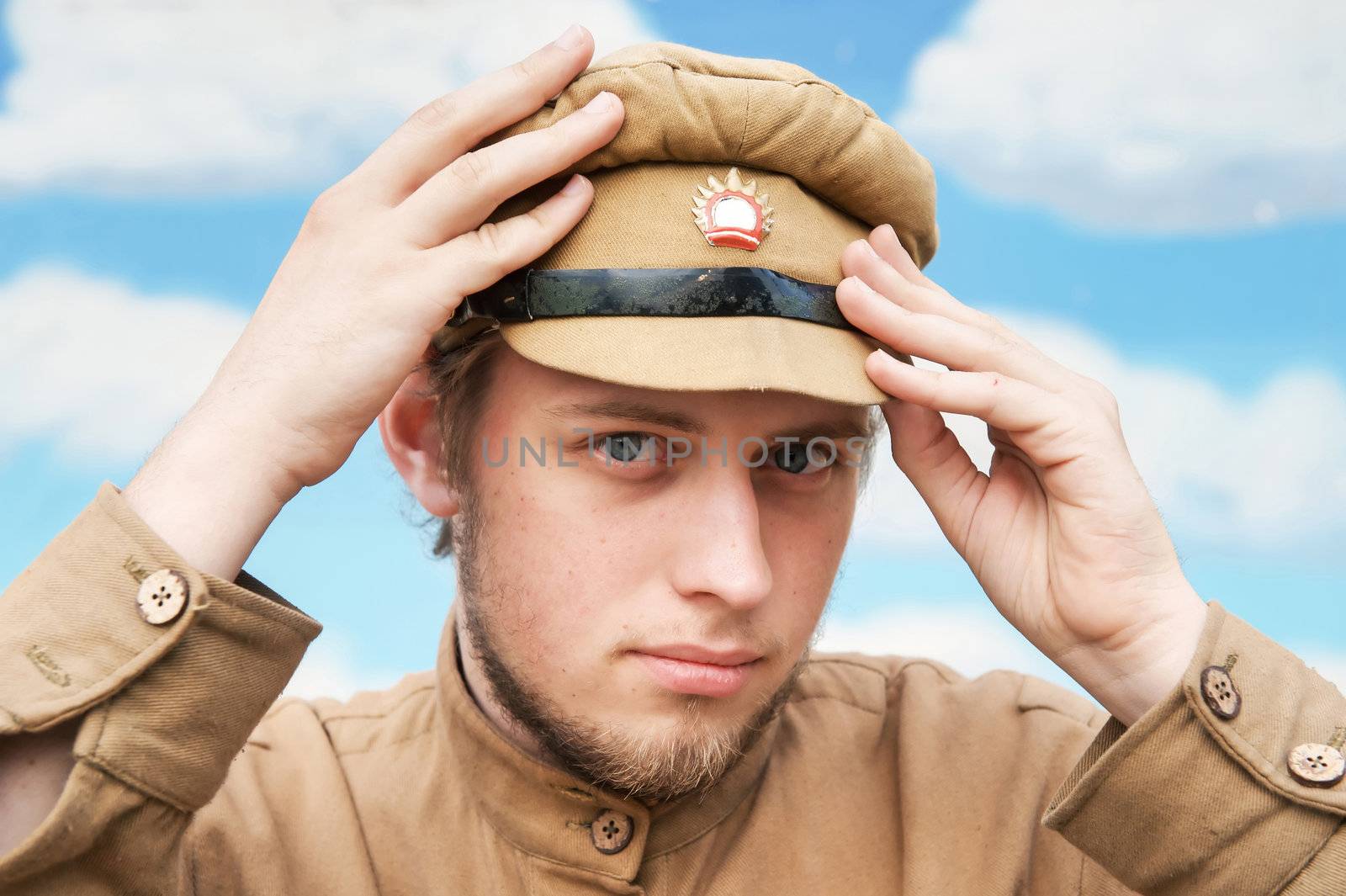 Portrait of soldier in uniform of World War 1 on the background of blue sky. Costume accord the times of World War I. Photo made at cinema city Cinevilla in Latvia. Cockade on the hat do not contain trade mark.