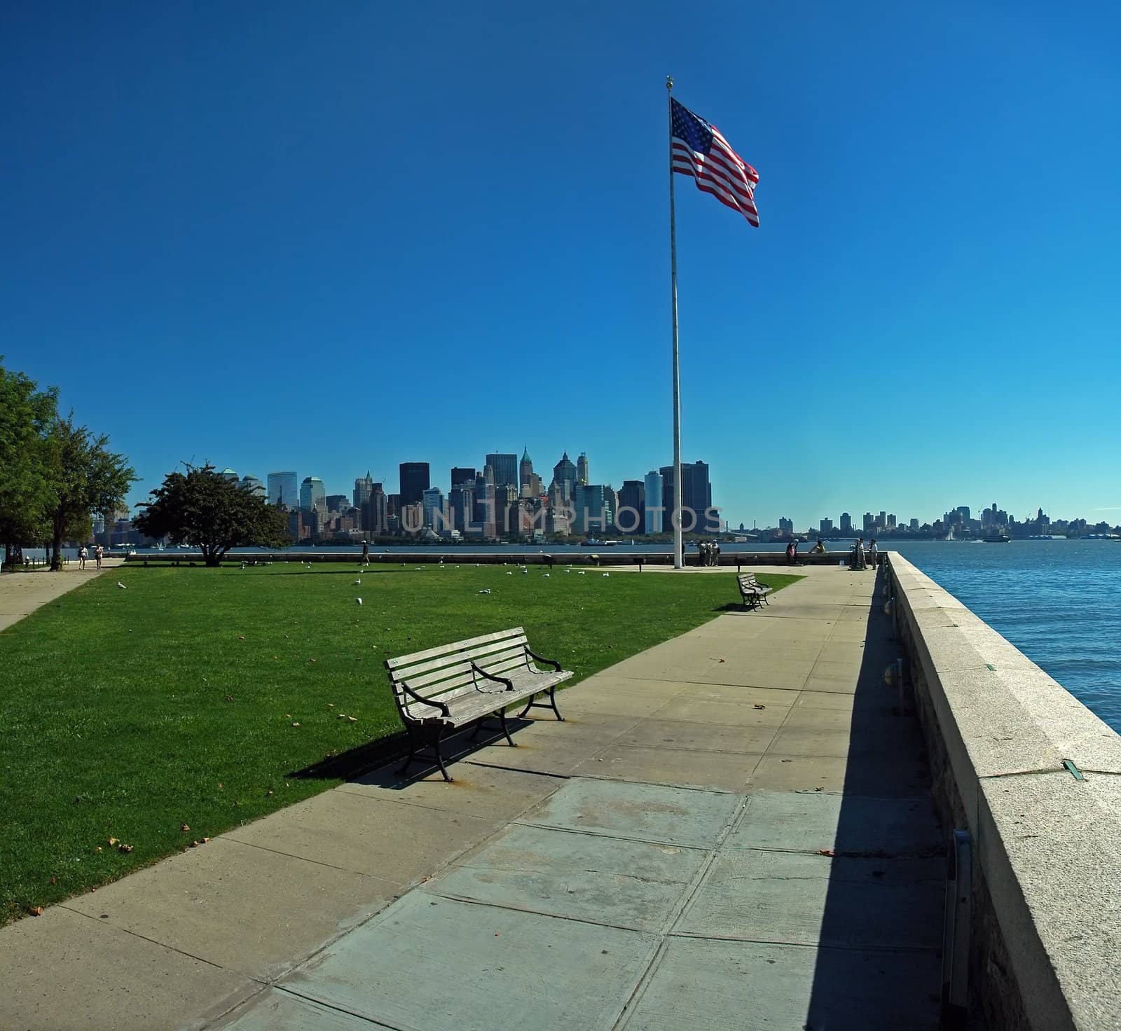 american flag and lower manhattan in background, photo taken from ellis island