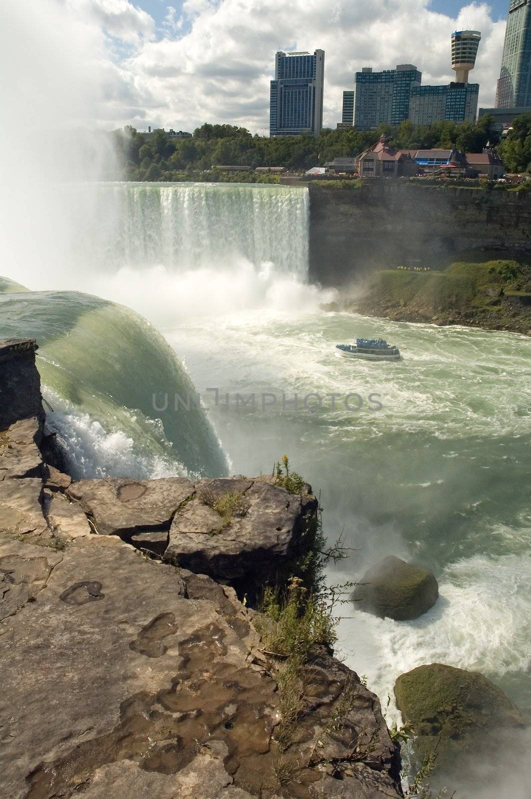 niagara falls, photo taken from united states, boat on horseshoe falls, canadian building in background