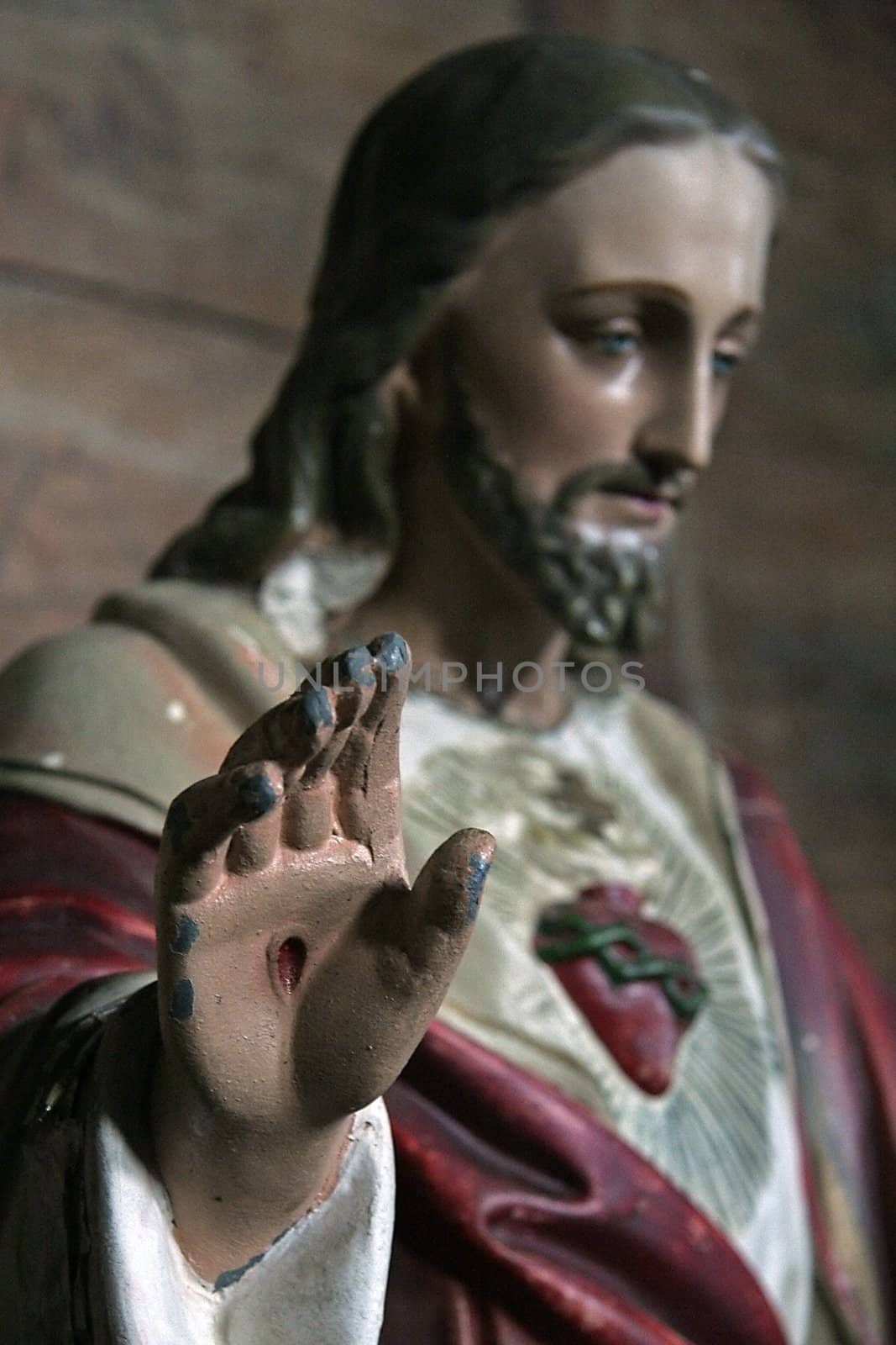 wooden jesus sculpture, hand in focused detail,