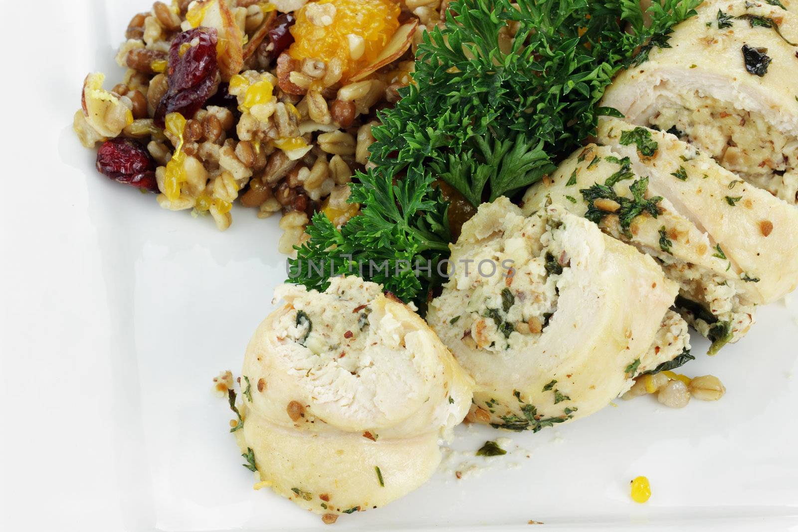 Chicken Roulade stuffed with spinach and almond paste served with pilaf with whole grains, nuts, and dried fruit.