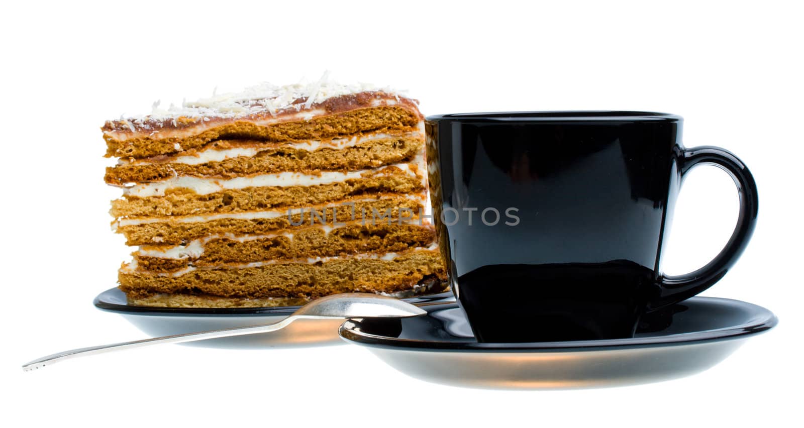 black cup and piece of honey cake, isolated on white