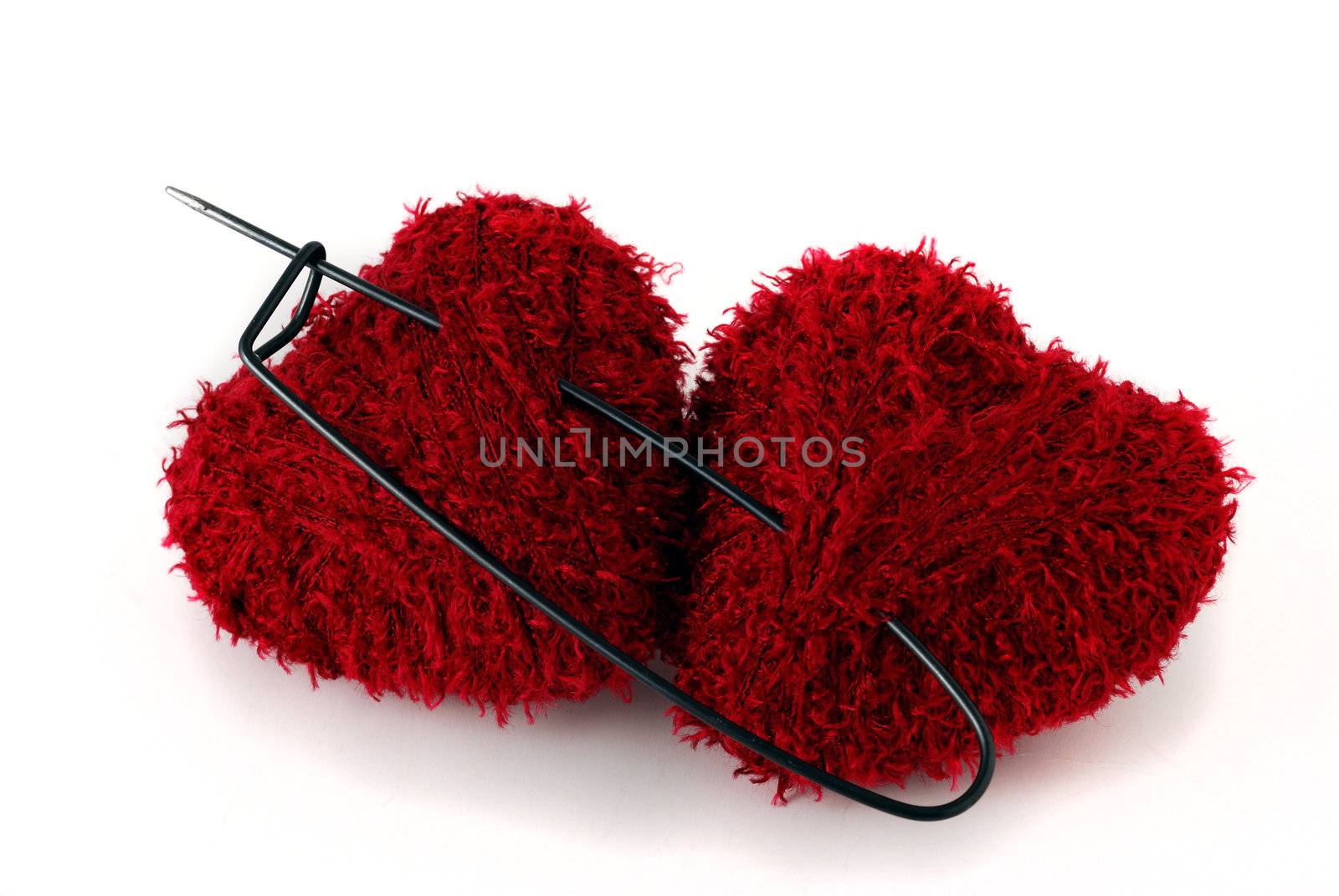 Two heart shaped clews pinned with huge pin on white background