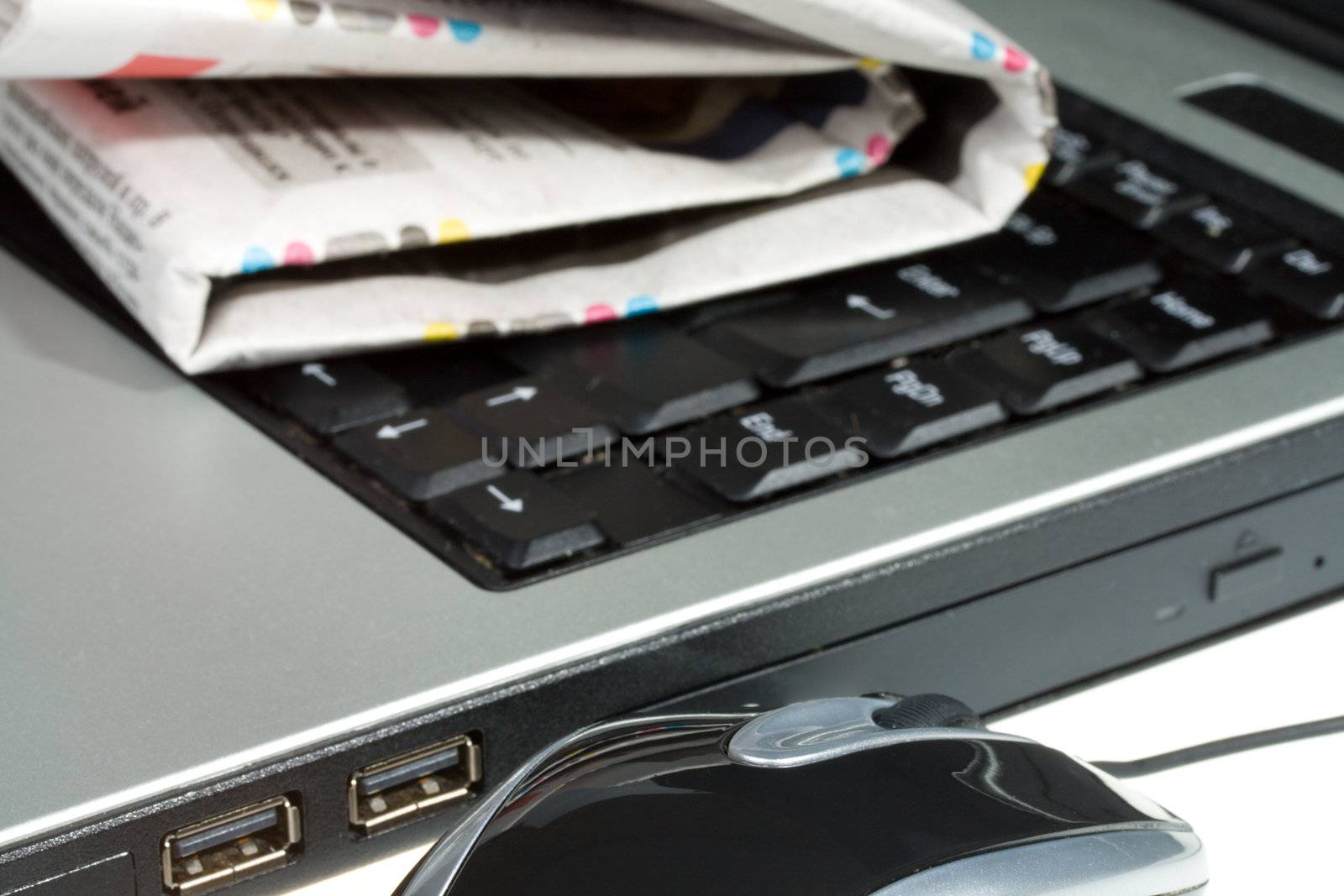 close-up laptop mouse and newspaper