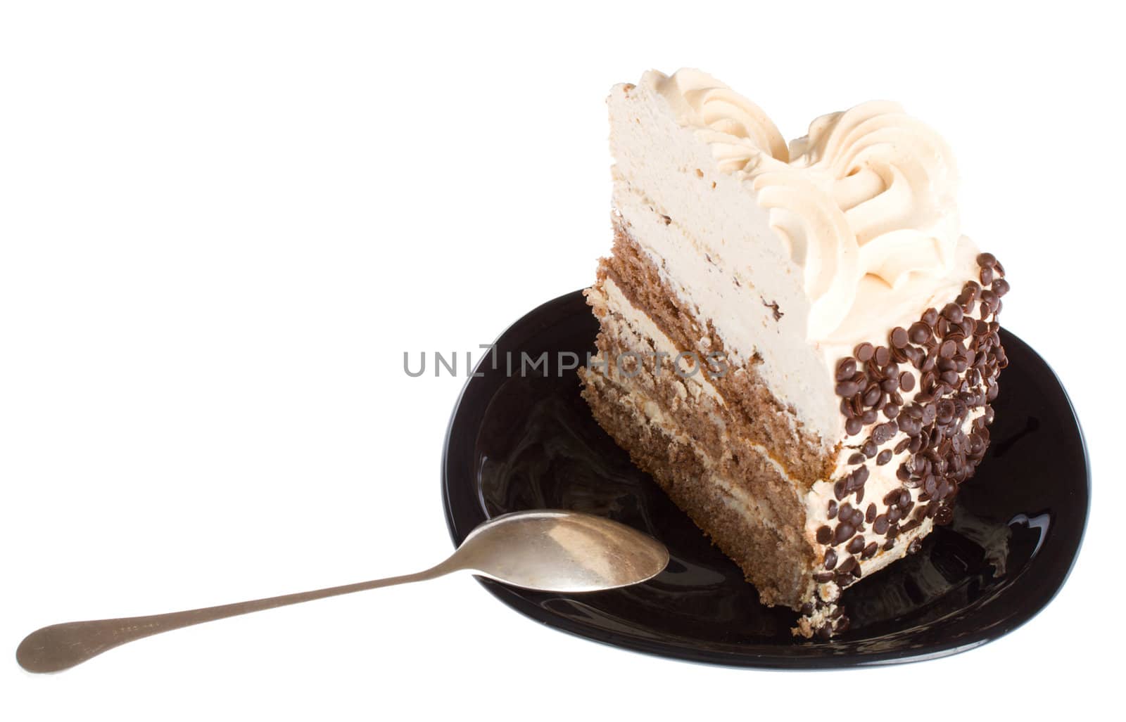 close-up piece of cake and spoon on black plate, isolated