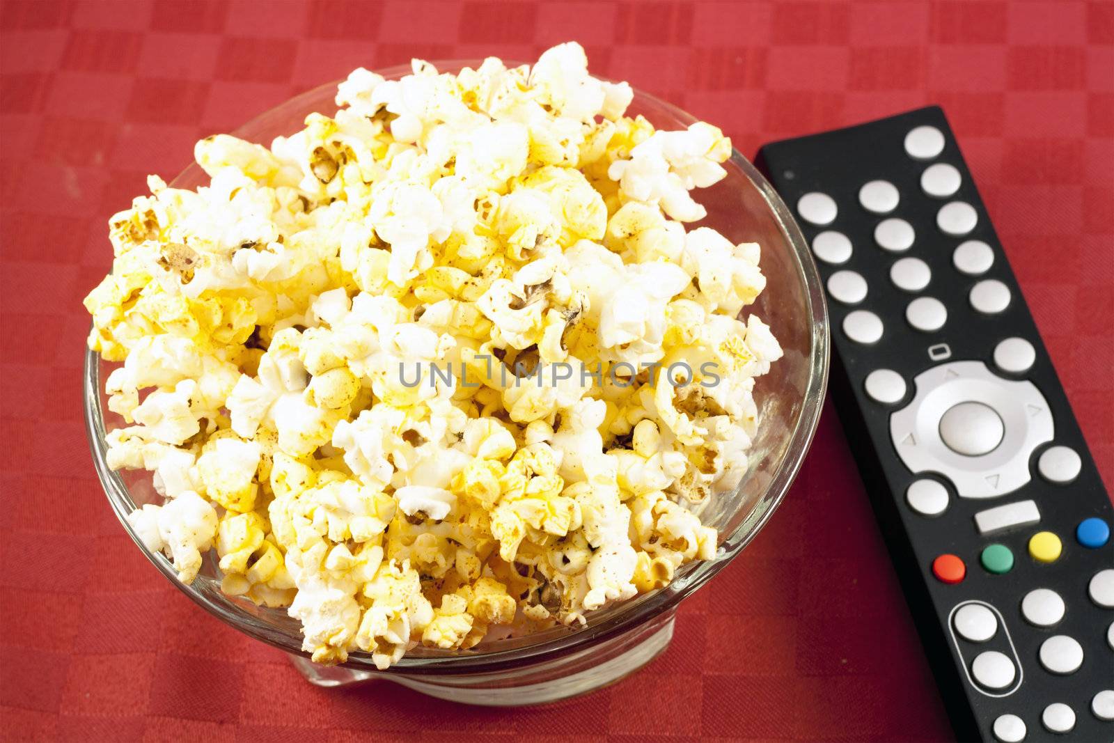 Bowl of popcorn on the table and remote control for TV