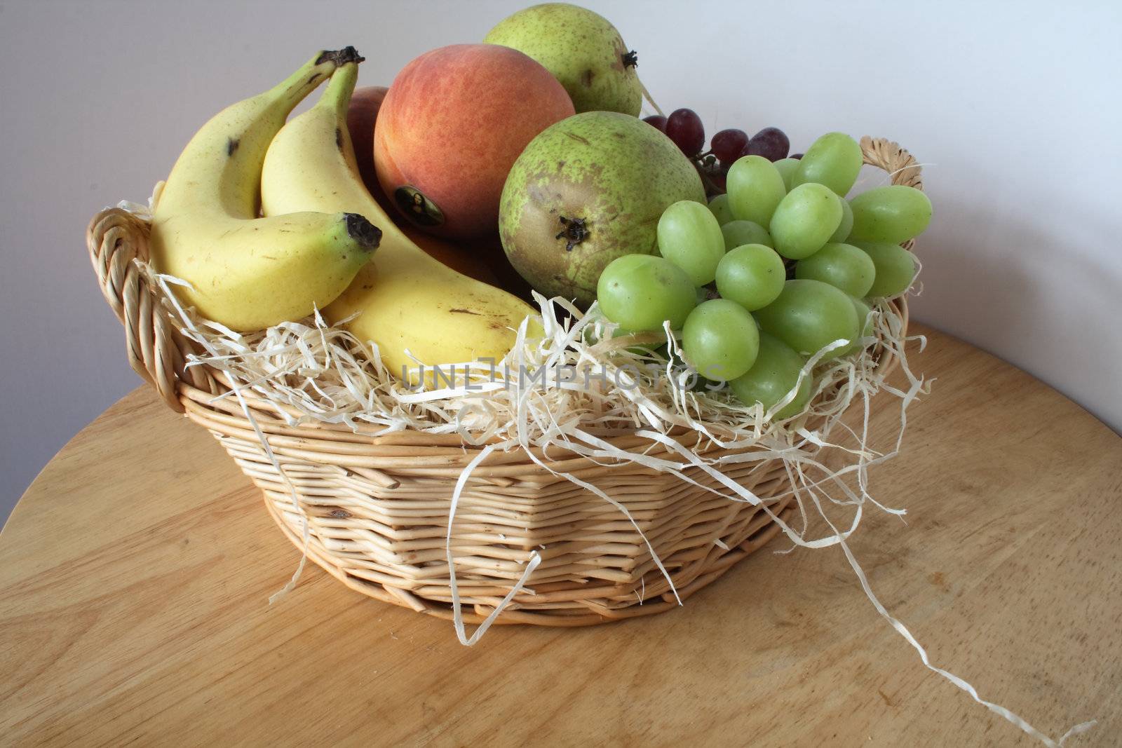 gift basket of fresh fruit with wood shaving interior