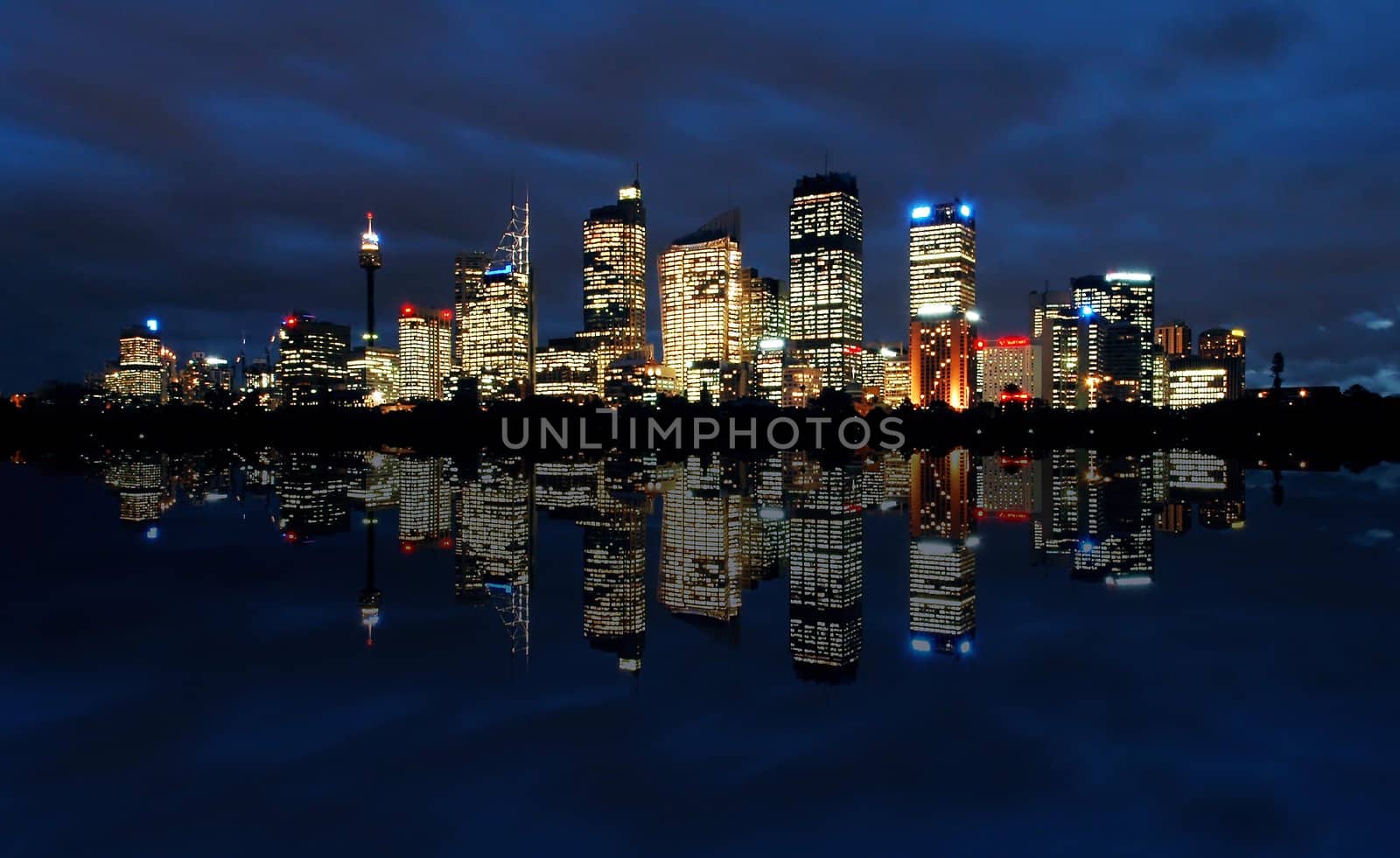 sydney cbd panorama at night, buildings reflection in water, dark cloudy night sky