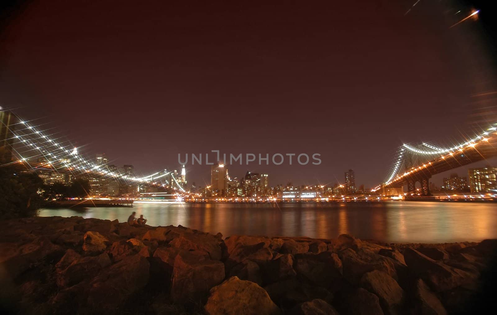 brooklyn and manhattan bridge night photo, rocks in foreground, star filter used to bring up the lights