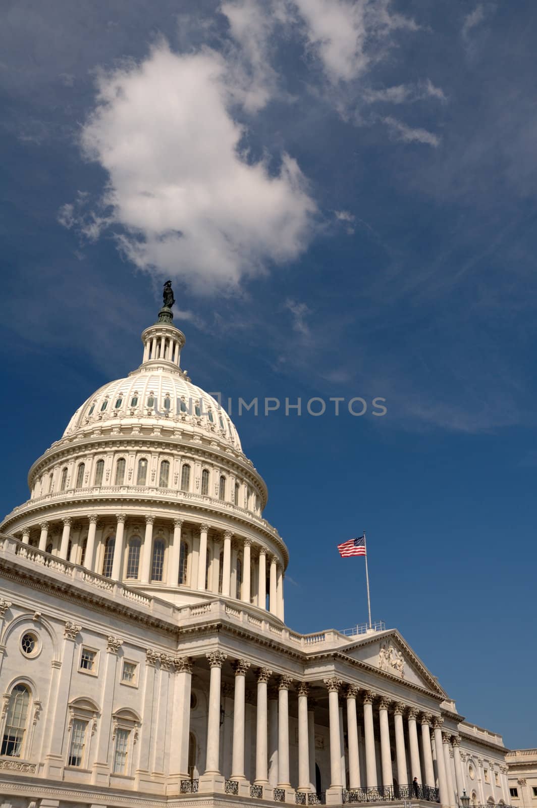The Capitol building lit against a dark sky, Washington DC, white cloud just above the roof