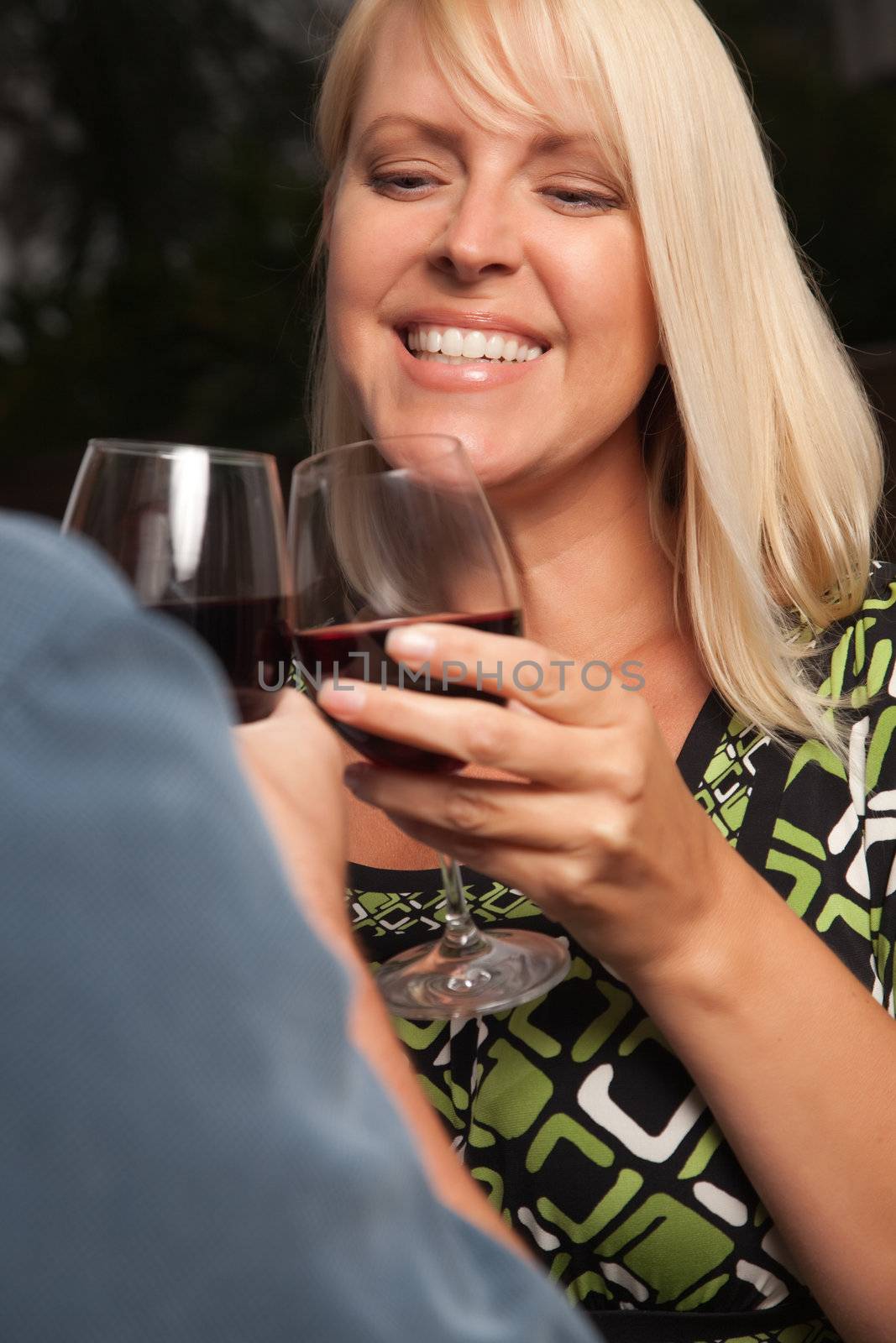 Wine Drinking Blonde Socializing with Man at an Evening Gathering.