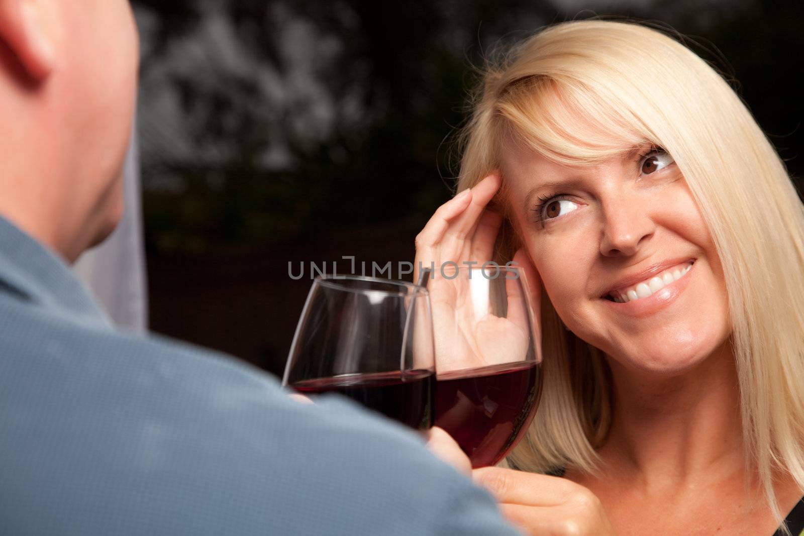 Wine Drinking Blonde Socializing with Man at an Evening Gathering.