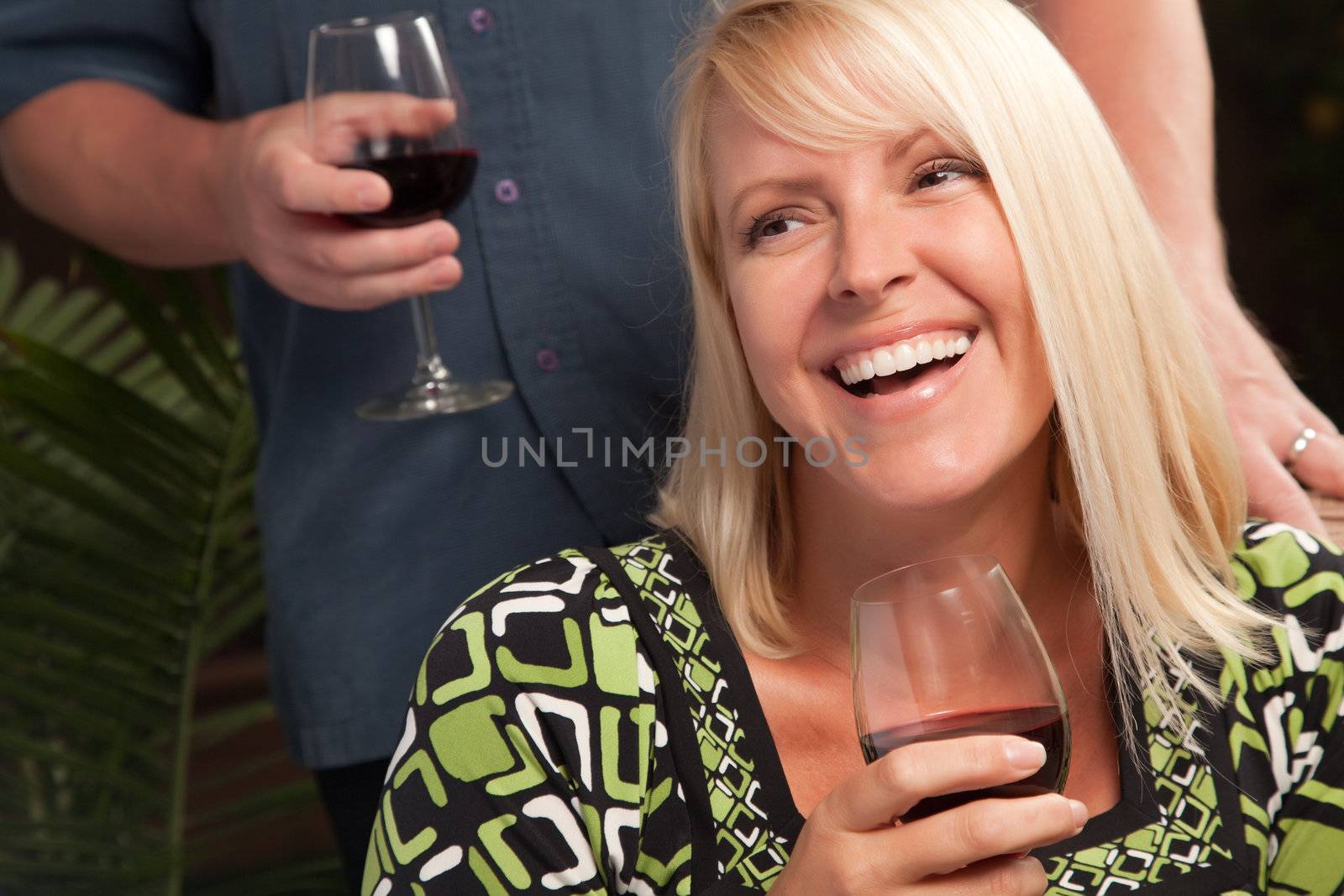 Wine Drinking Blonde Socializing with Man at an Evening Gathering.