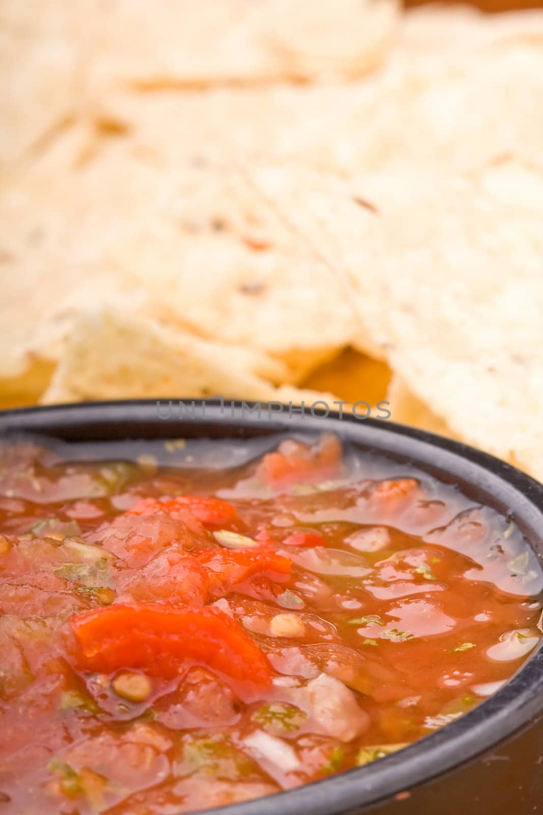 fresh salsa in a black bowl and corn chips 