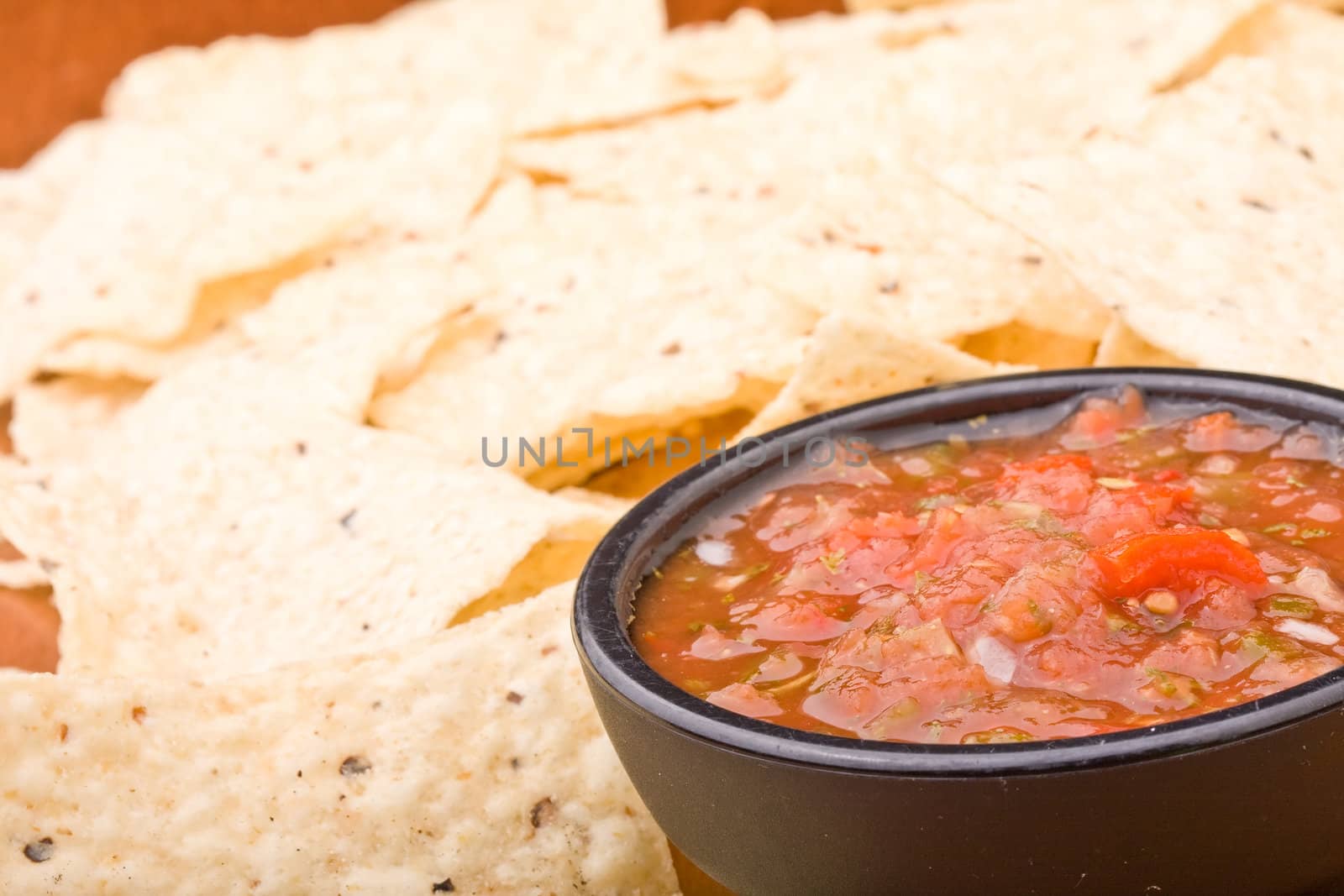 fresh salsa in a black bowl and corn chips 