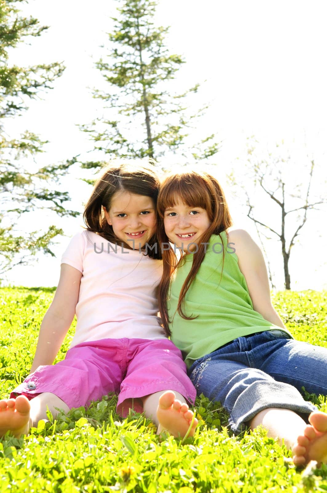 Portrait of happy girls sitting on grass