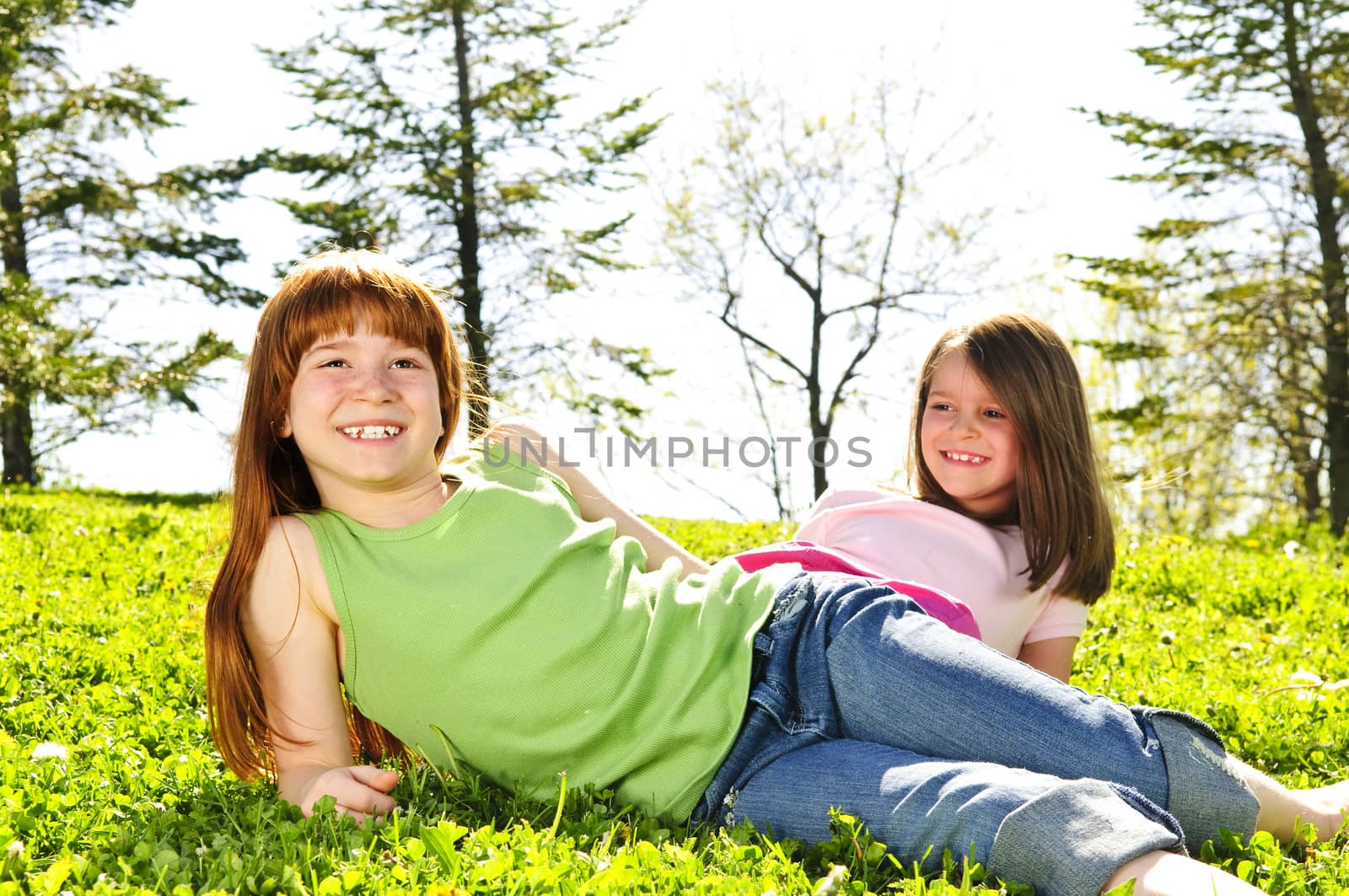 Portrait of happy girls sitting on grass