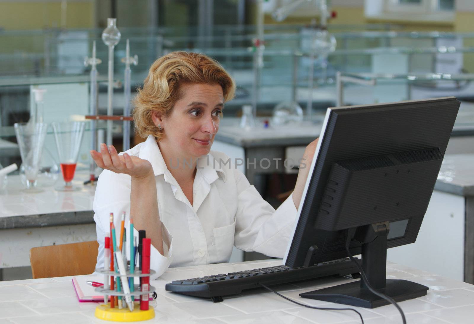 Female researcher having a positive reaction while looking at something on the computer monitor in a laboratory.
