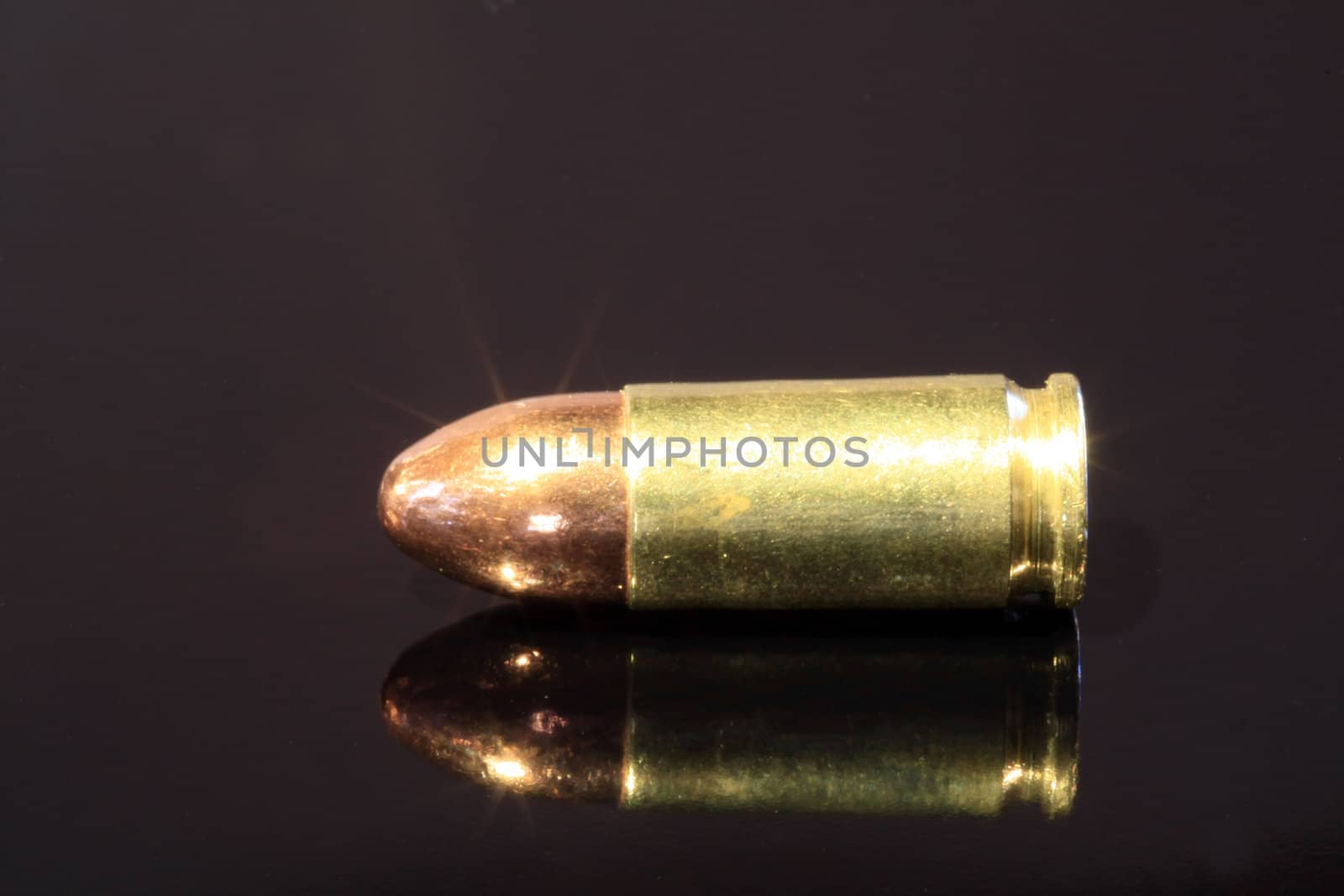 9mm bullet on black surface by ChrisAlleaume