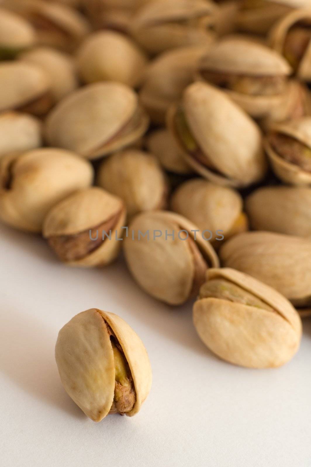 multiple salted pistachios, warm brown color, distance blur