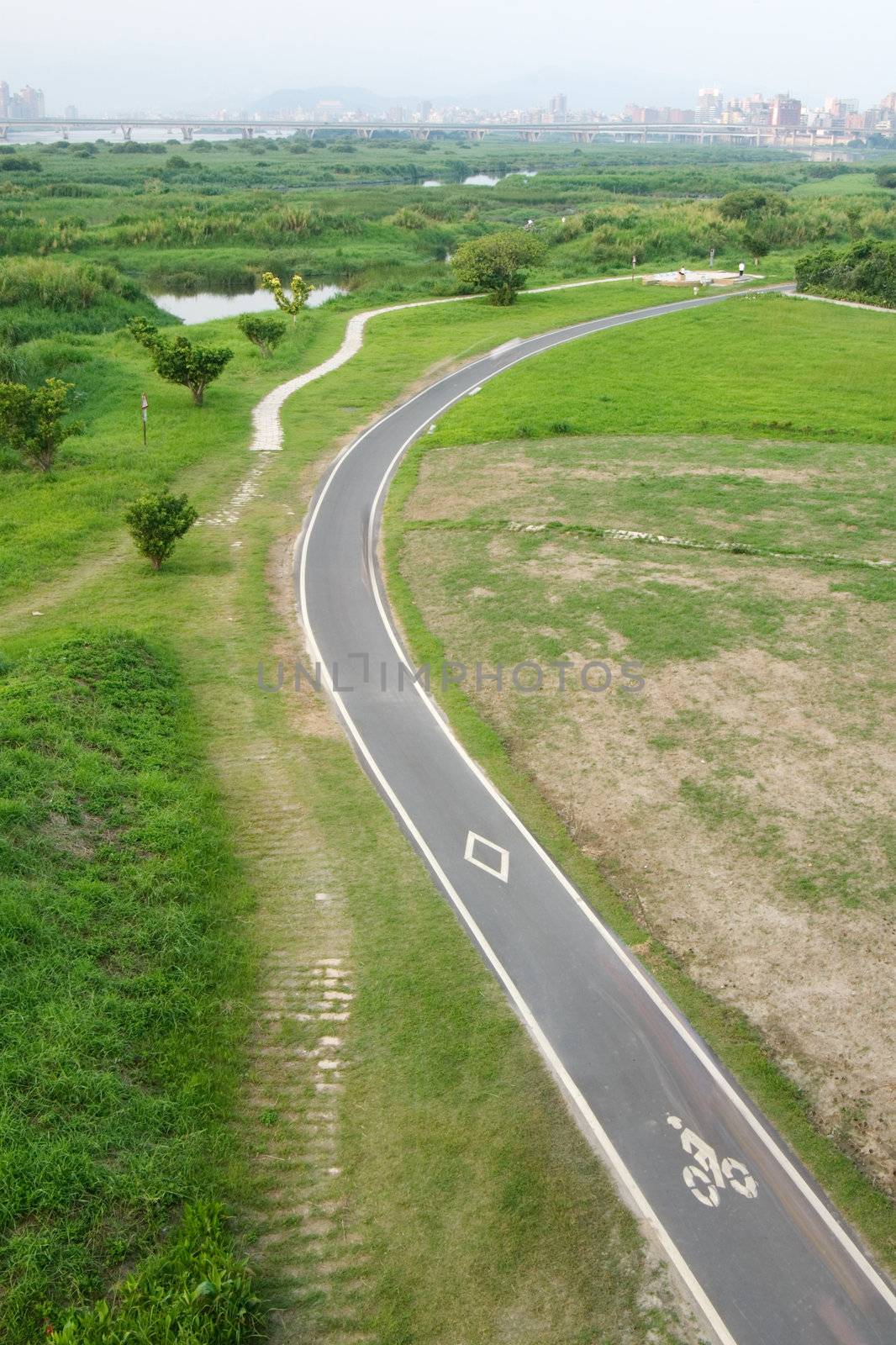 It is a road for bicycle on the grassland.