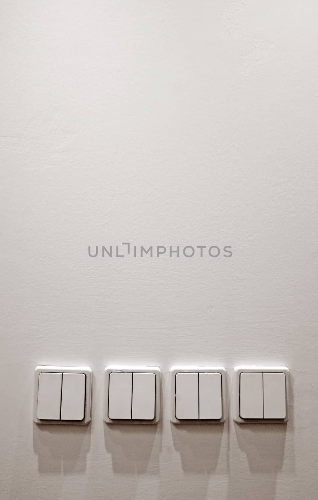 white wall with four plastic light switches, 