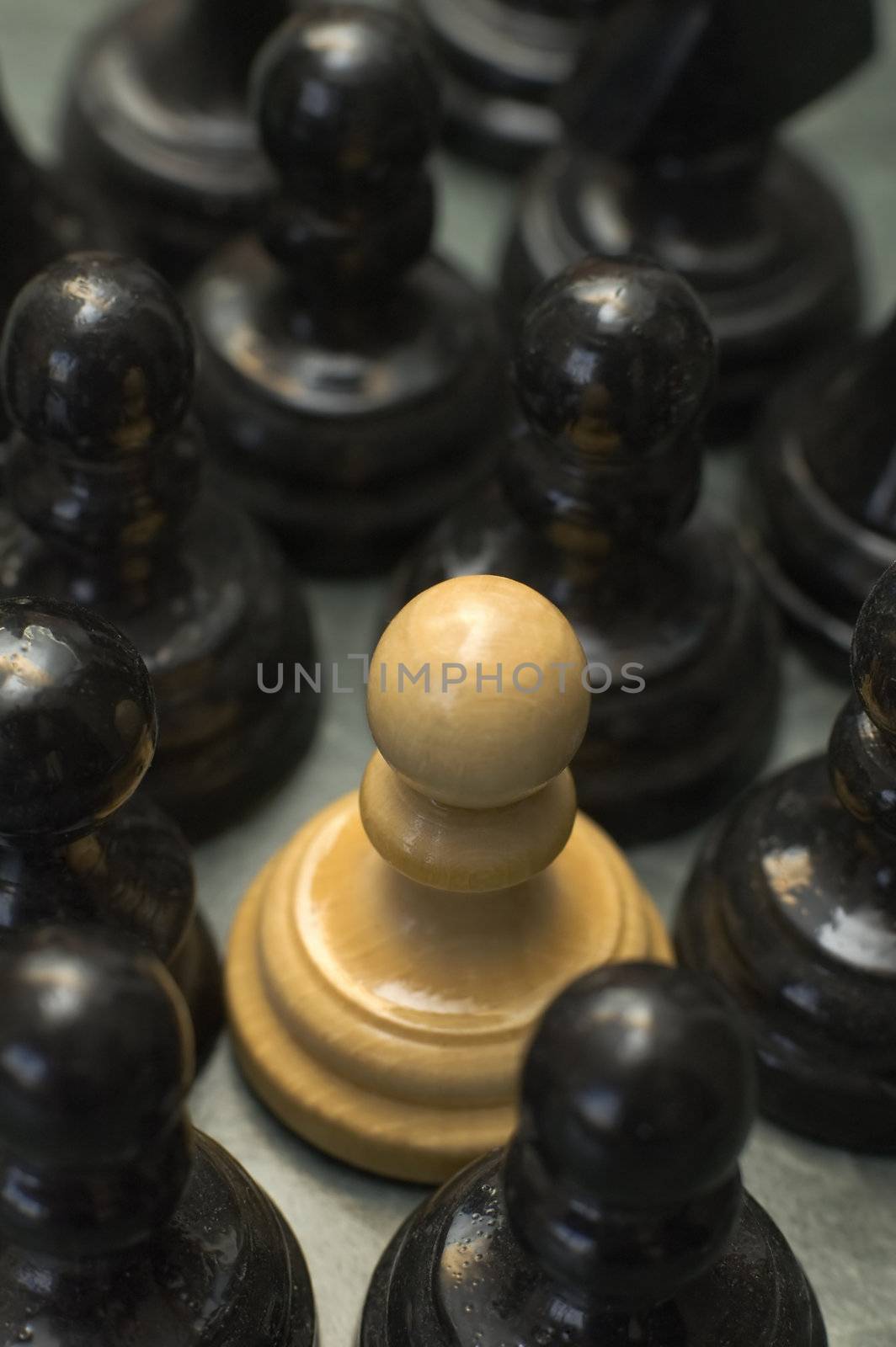 white pawn in the middle of black pawns, conceptual theme