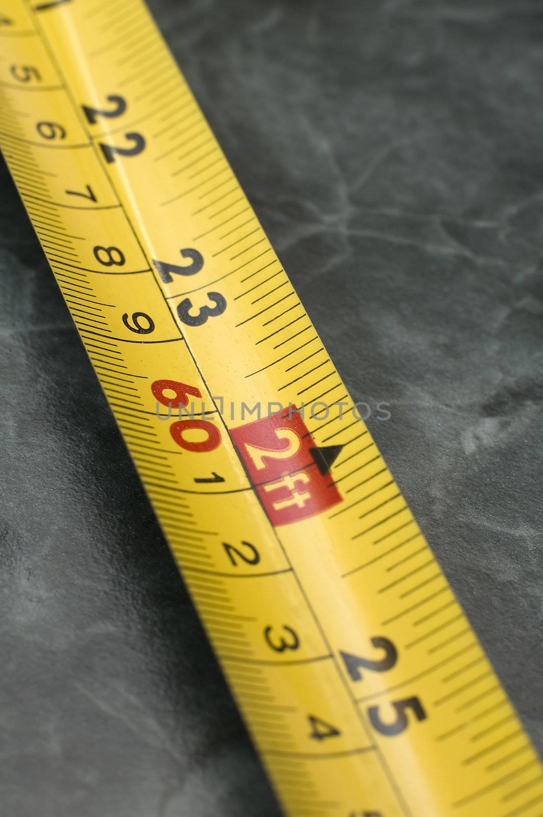 yellow Measuring Tape in centimeters and feets, distance blur, marble background