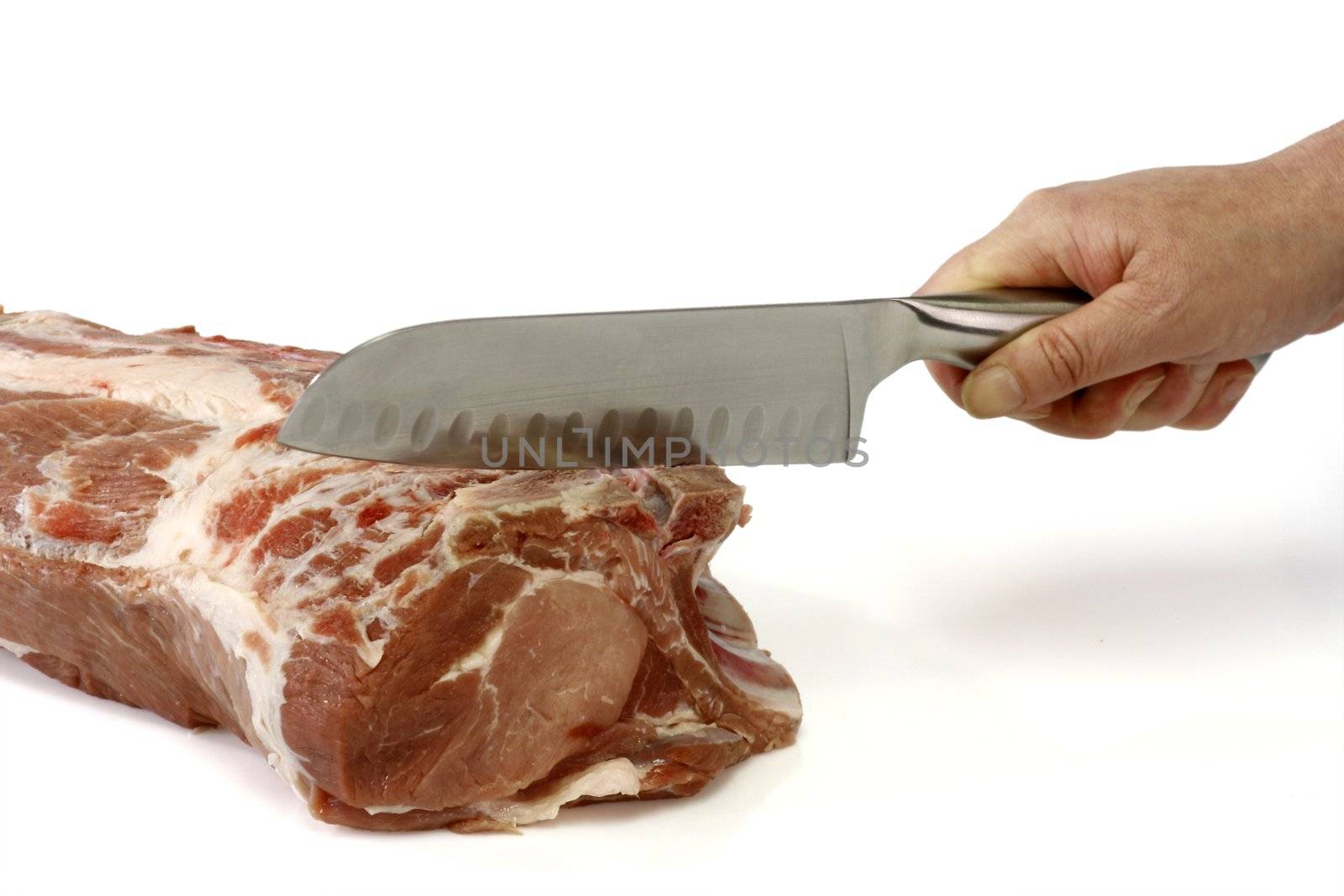 Hand chopping a raw pork roast - isolated over white background