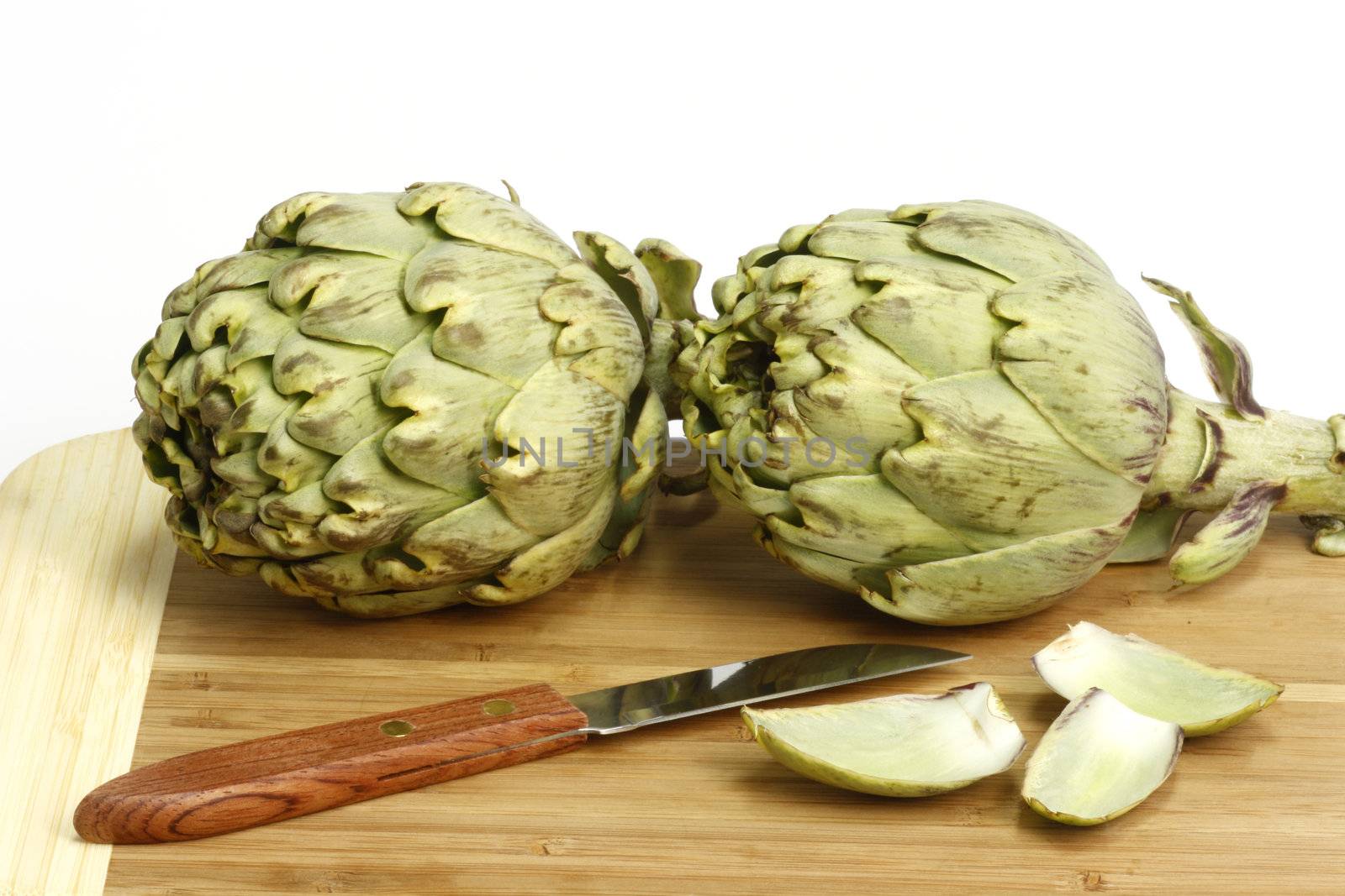 Preparation of fresh artichokes on a wooden plate