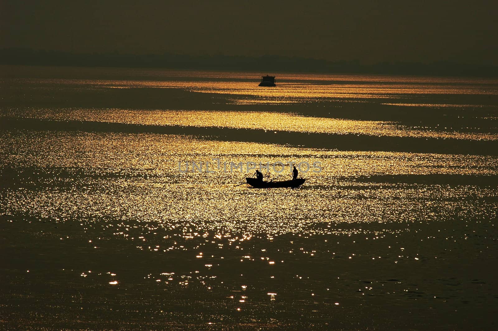 Silhouette of a filshing boat in lake at sunset