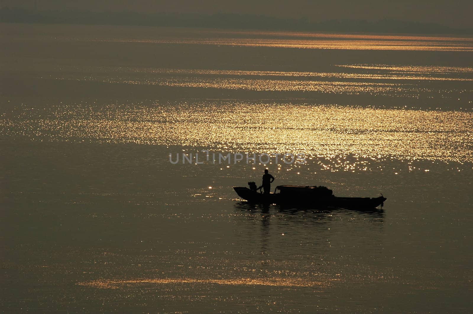 Silhouette of a filshing boat in lake at sunset