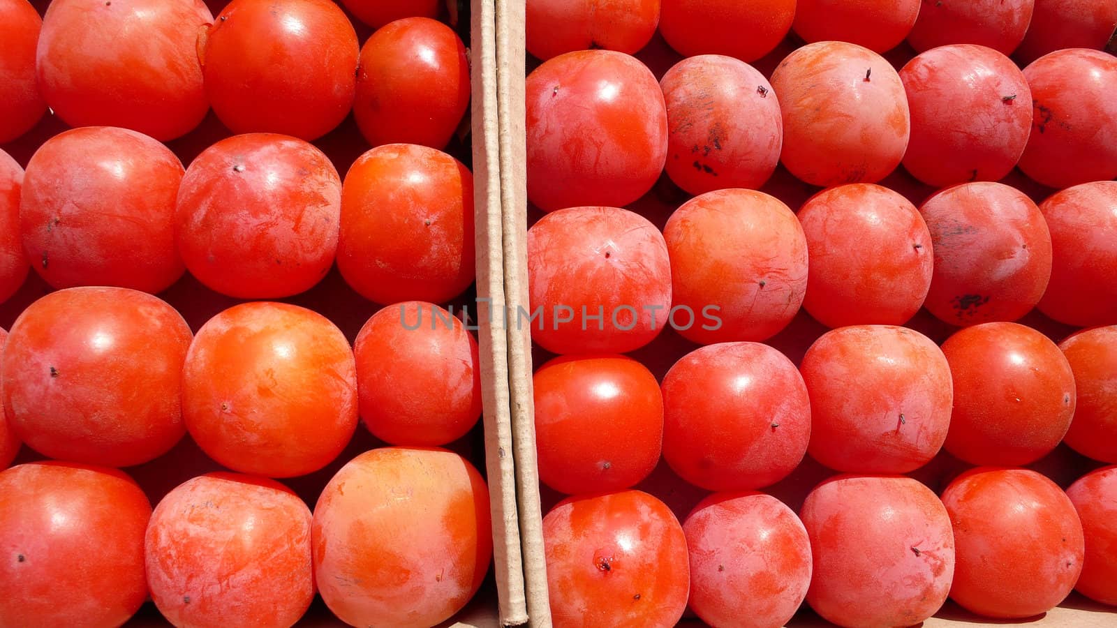 Closeup view of a pile of red persimmon fruits in autumn