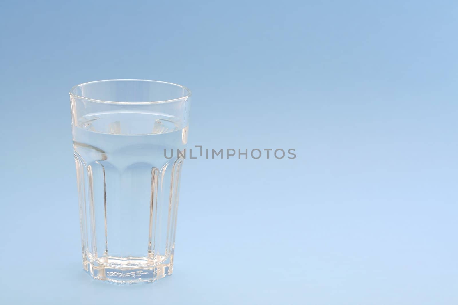 A glass of water with blue background