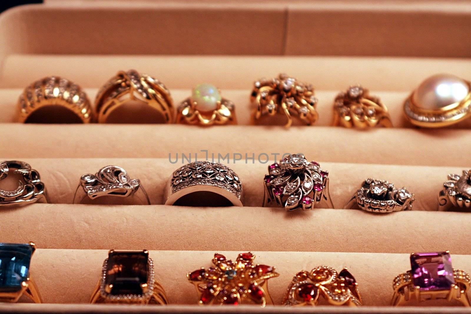 Open jewelry box with diamond and gemstone gold rings.