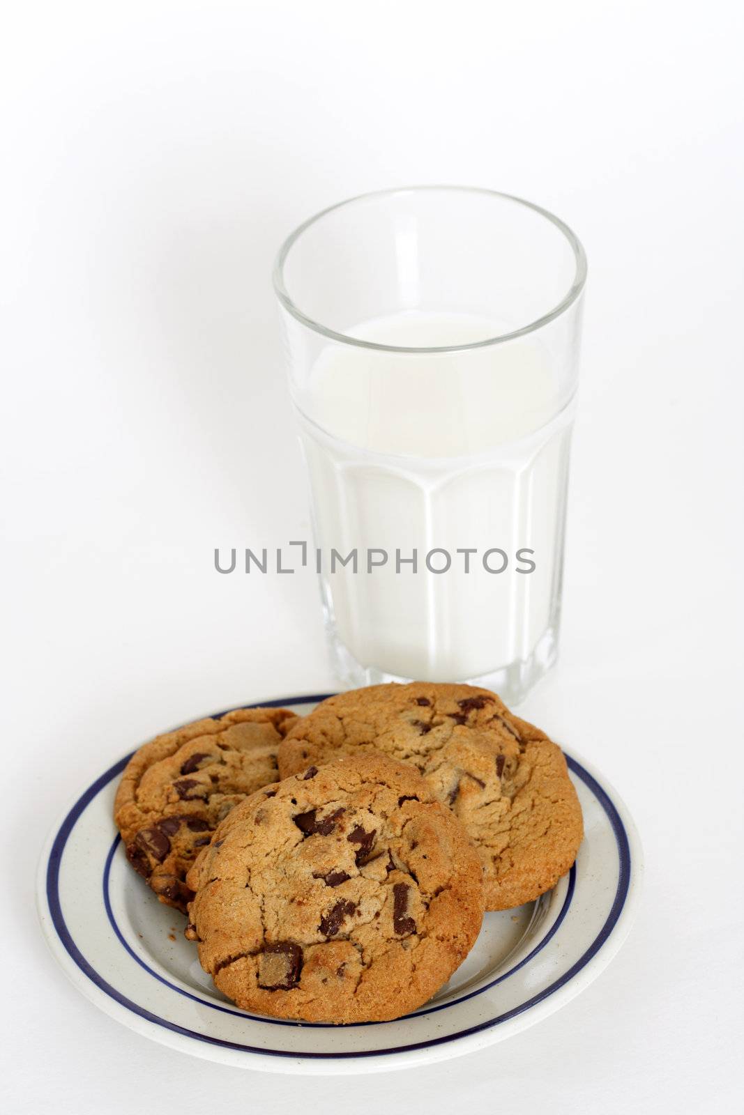 Three chocolate chips cookies and a glass of milk