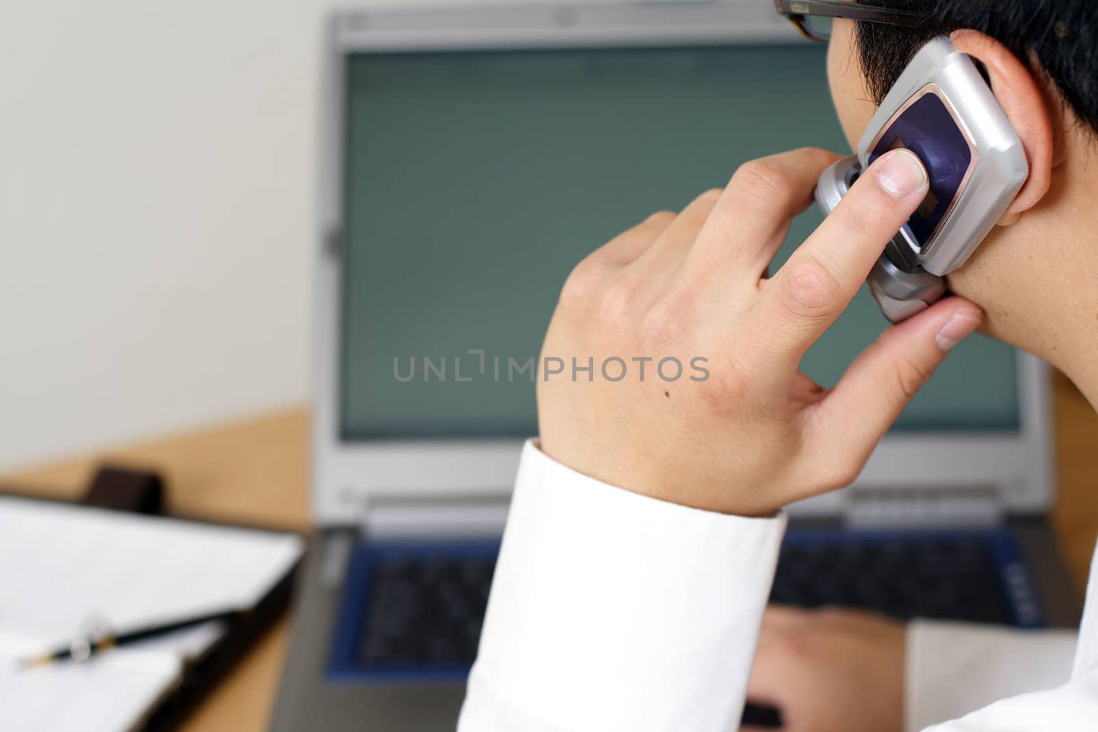 Businessman talking on cellphone at work