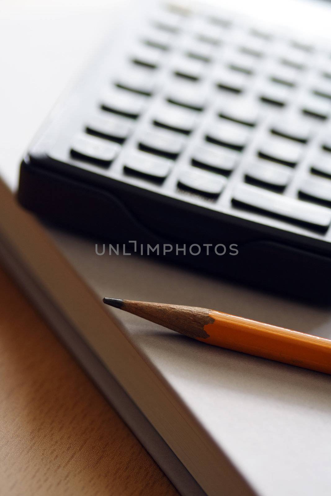 A pencil, calculator and book, for business/money concept