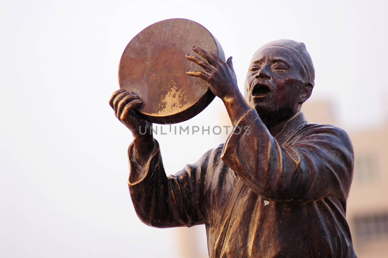 Statue of a man singing with drum