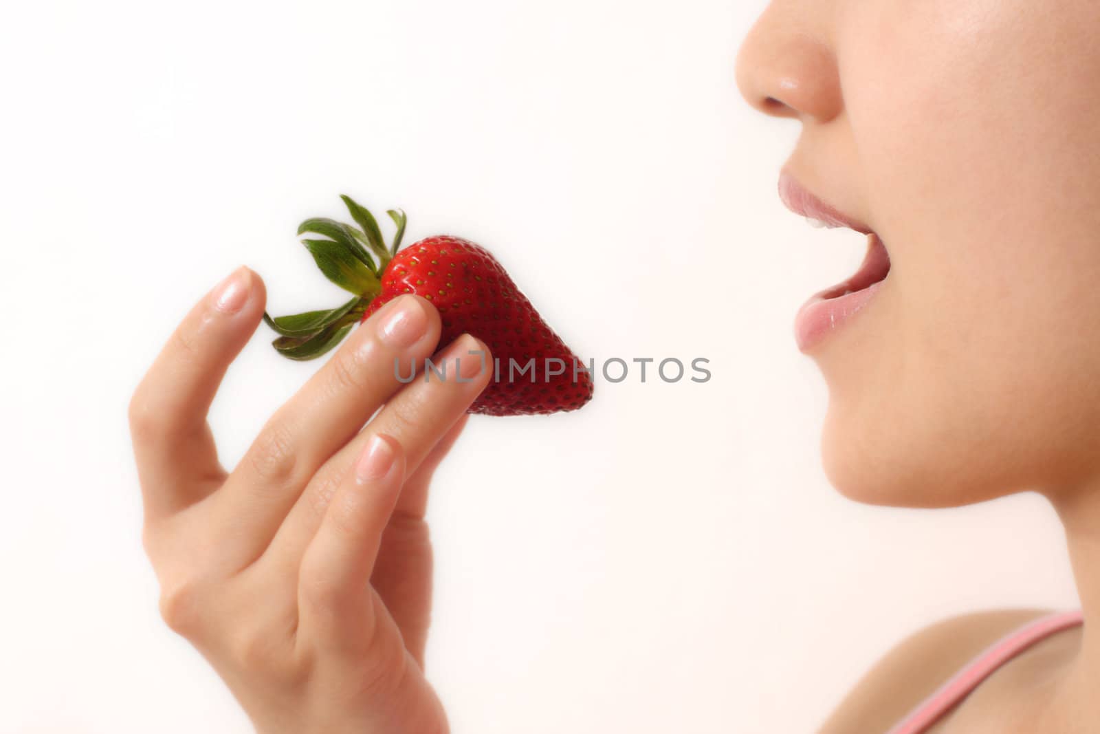 A woman eating a strawberry