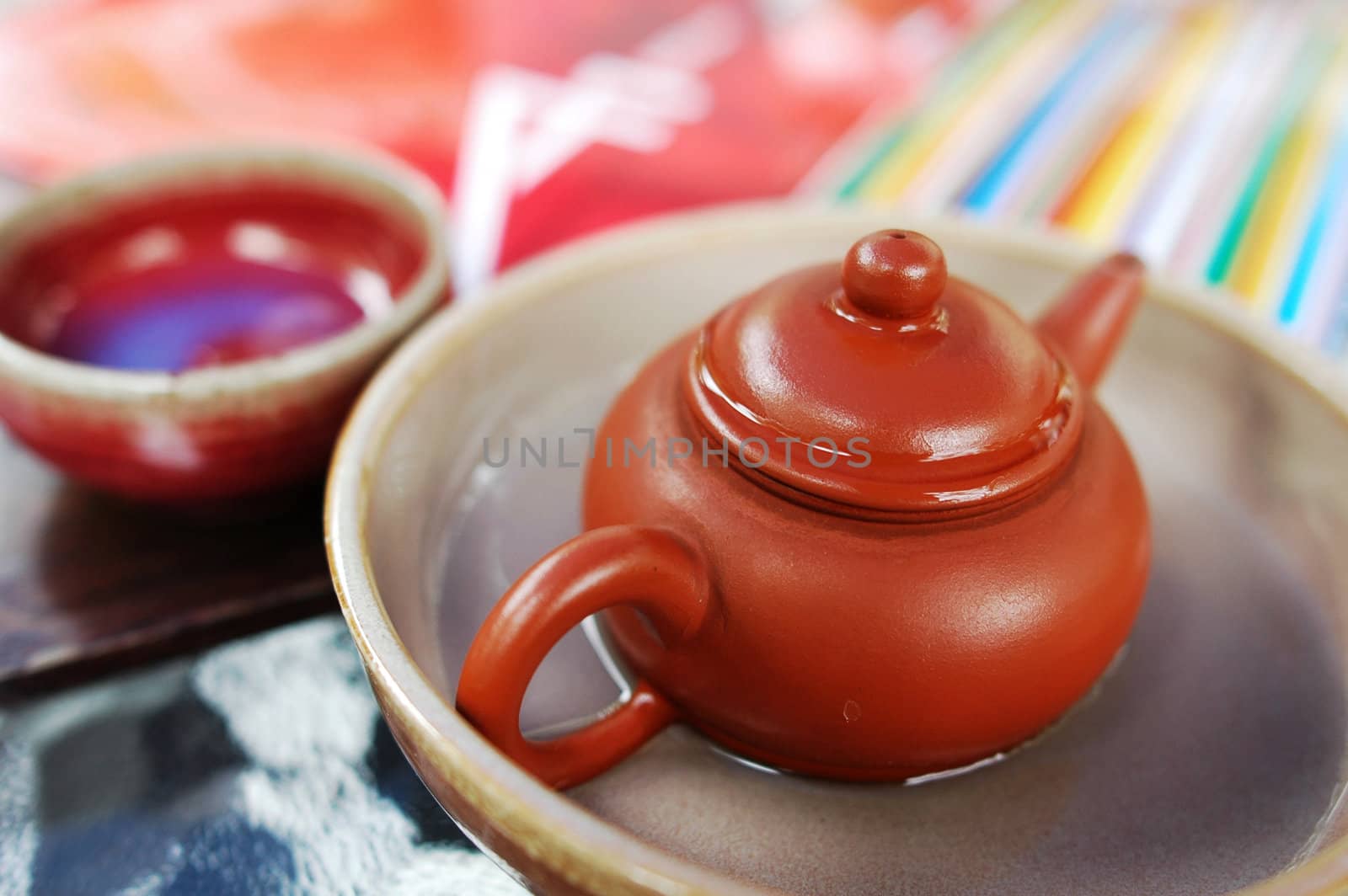 Closeup view of a pottery teapot with teacup 