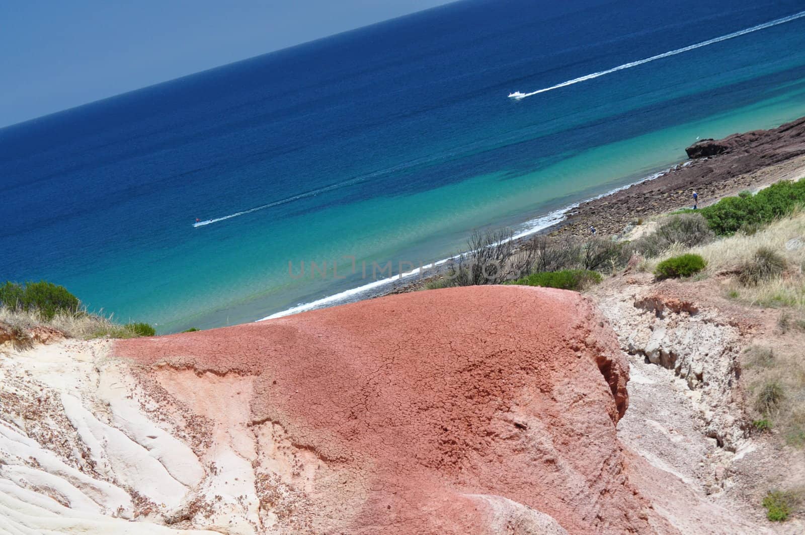 Beautiful azure, blue water beach with red stone. by dimkadimon