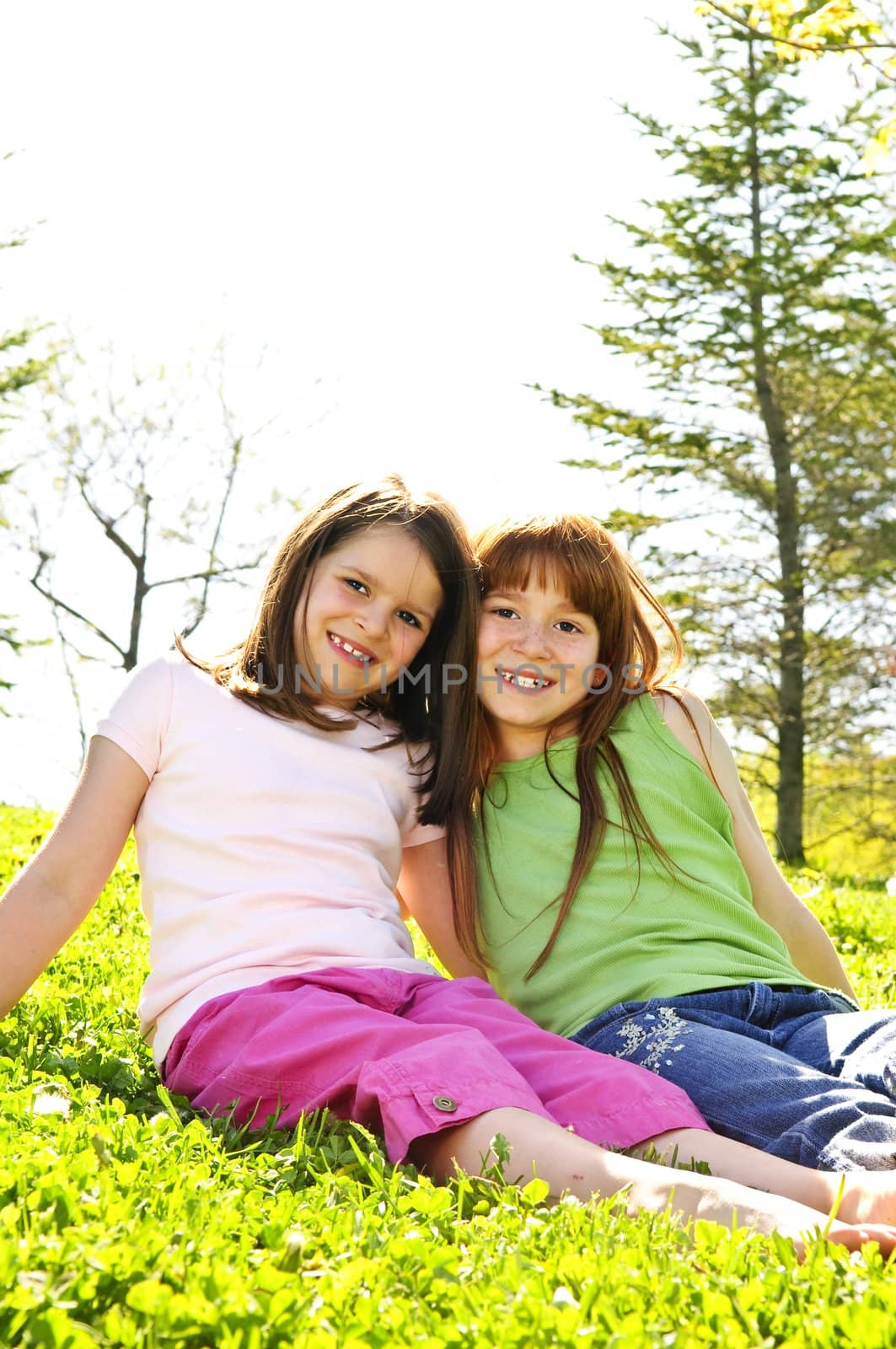 Portrait of happy girls sitting on grass