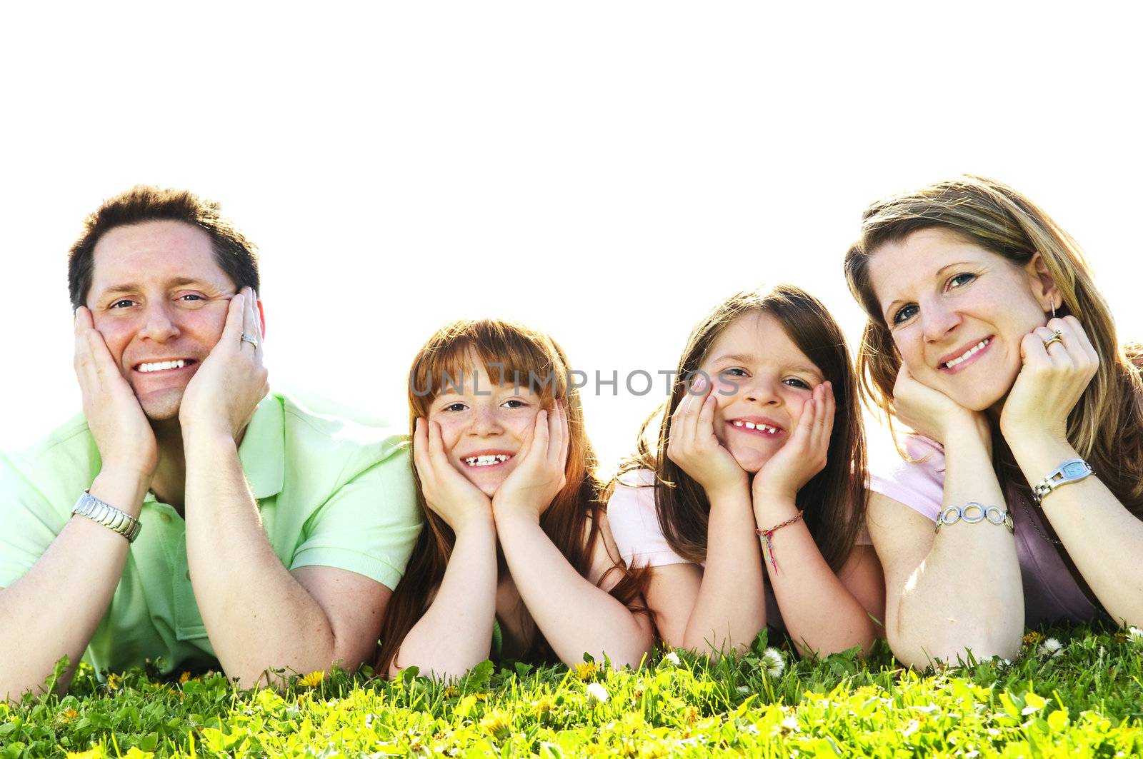 Portrait of happy family of four laying resting head on hands