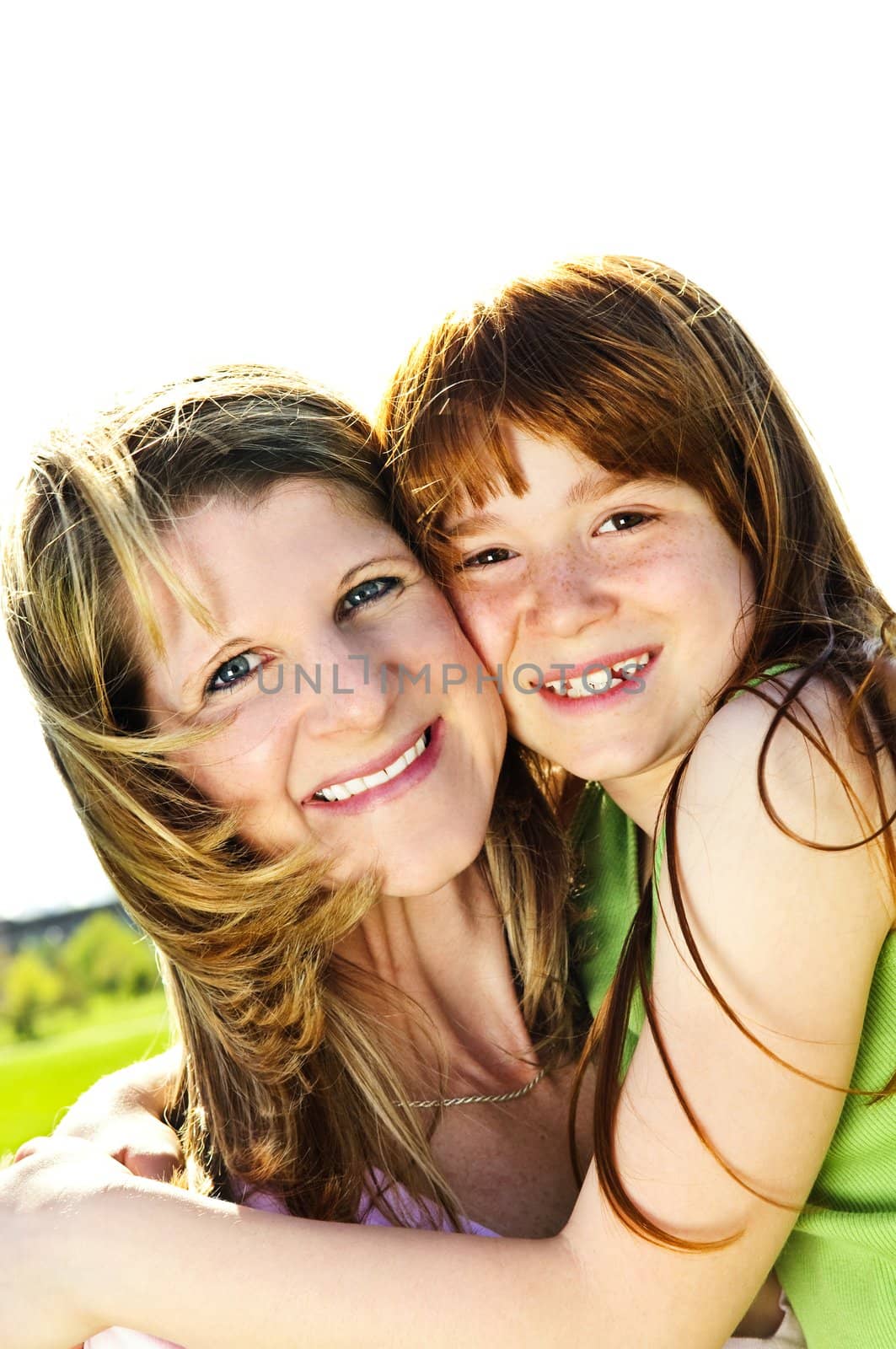 Portrait of happy child hugging her mother