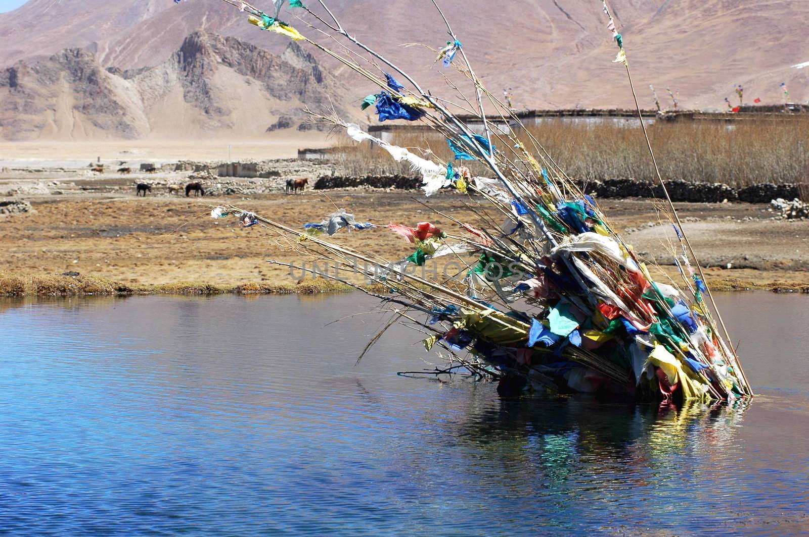 Landscape of colorful prayer flags in a lake in Tibet