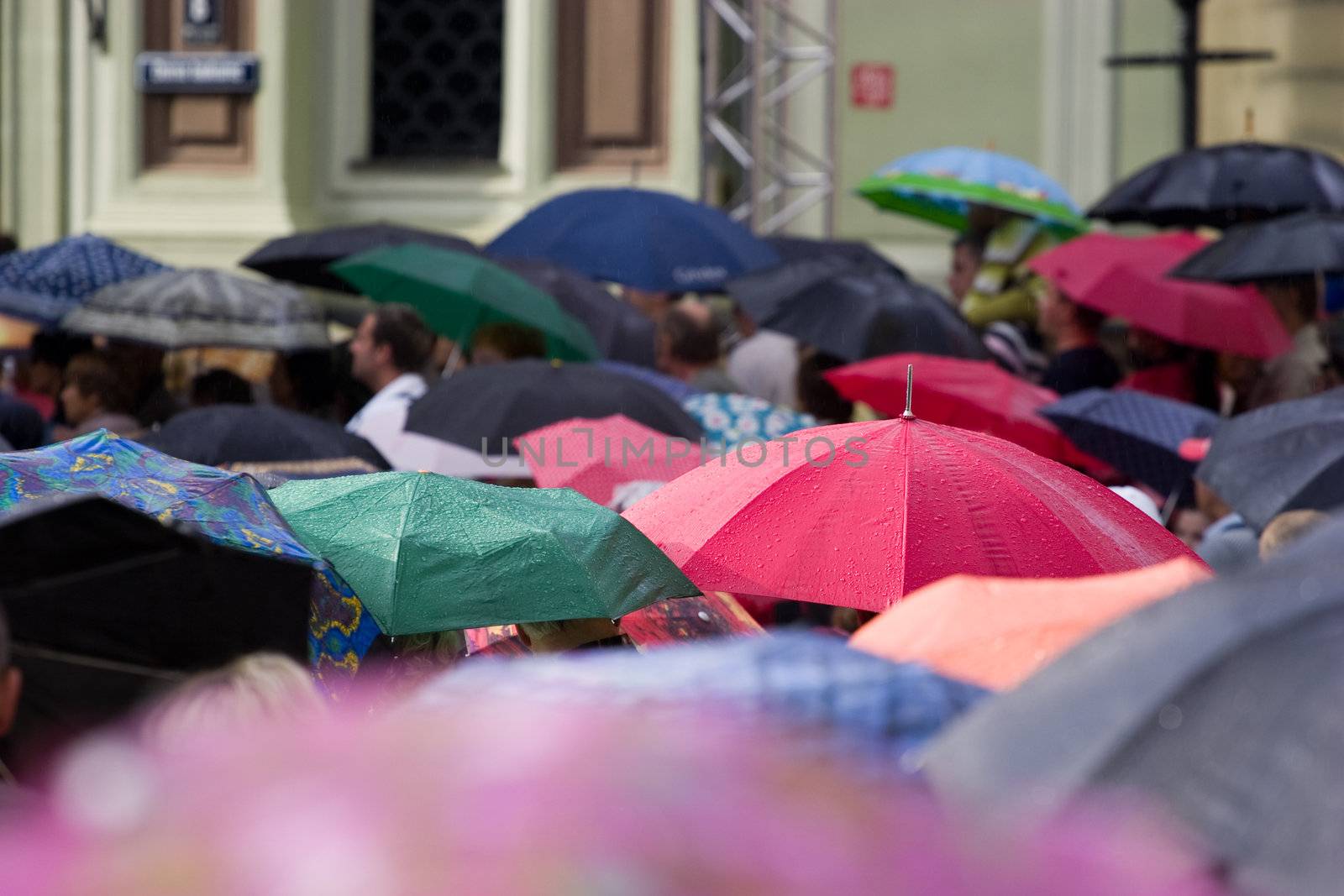 Busy street with crowd of people with umbrellas