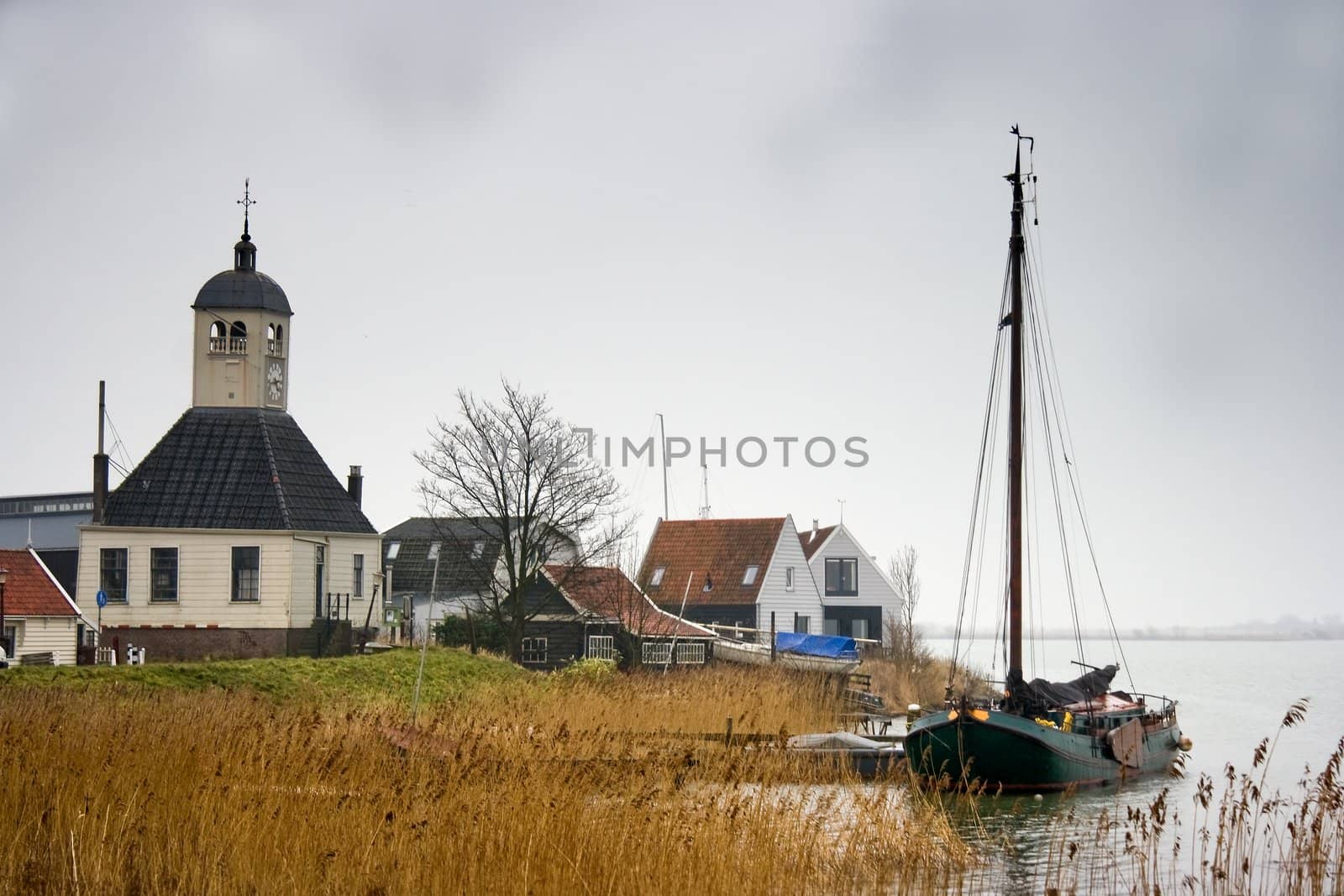 Fishing village and boat at the lake in winter by Colette