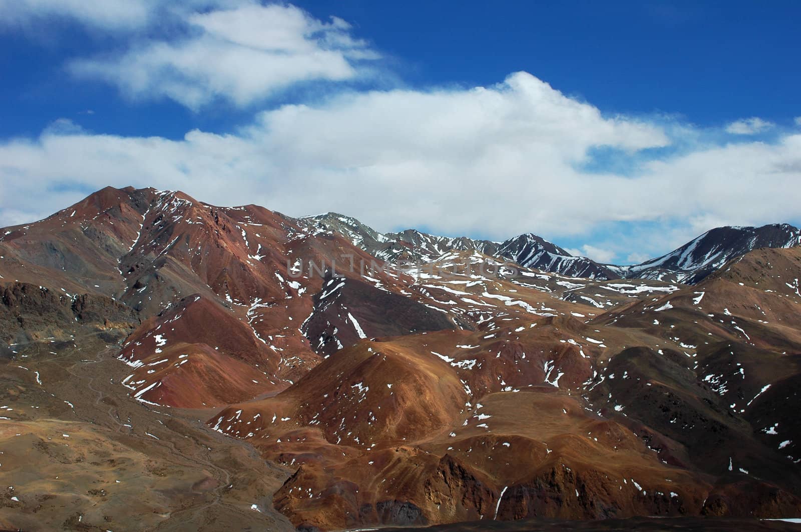 Landscape of red mountains dotted by snow in winter